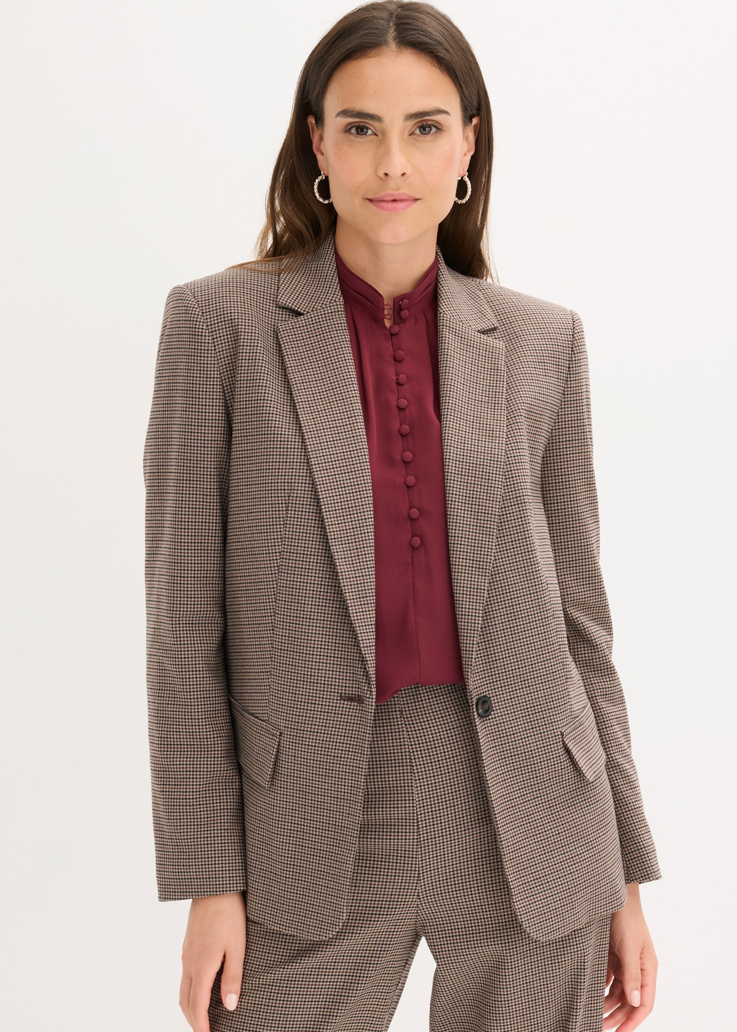 Elegantes Outfit mit kariertem Blazer, passender Hose und einer bordeauxroten Bluse.