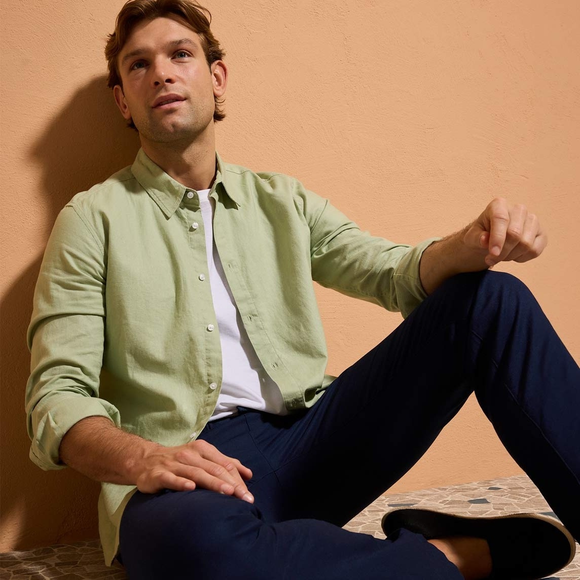 Hellgrünes Hemd über weißem T-Shirt, kombiniert mit dunkler Hose. 