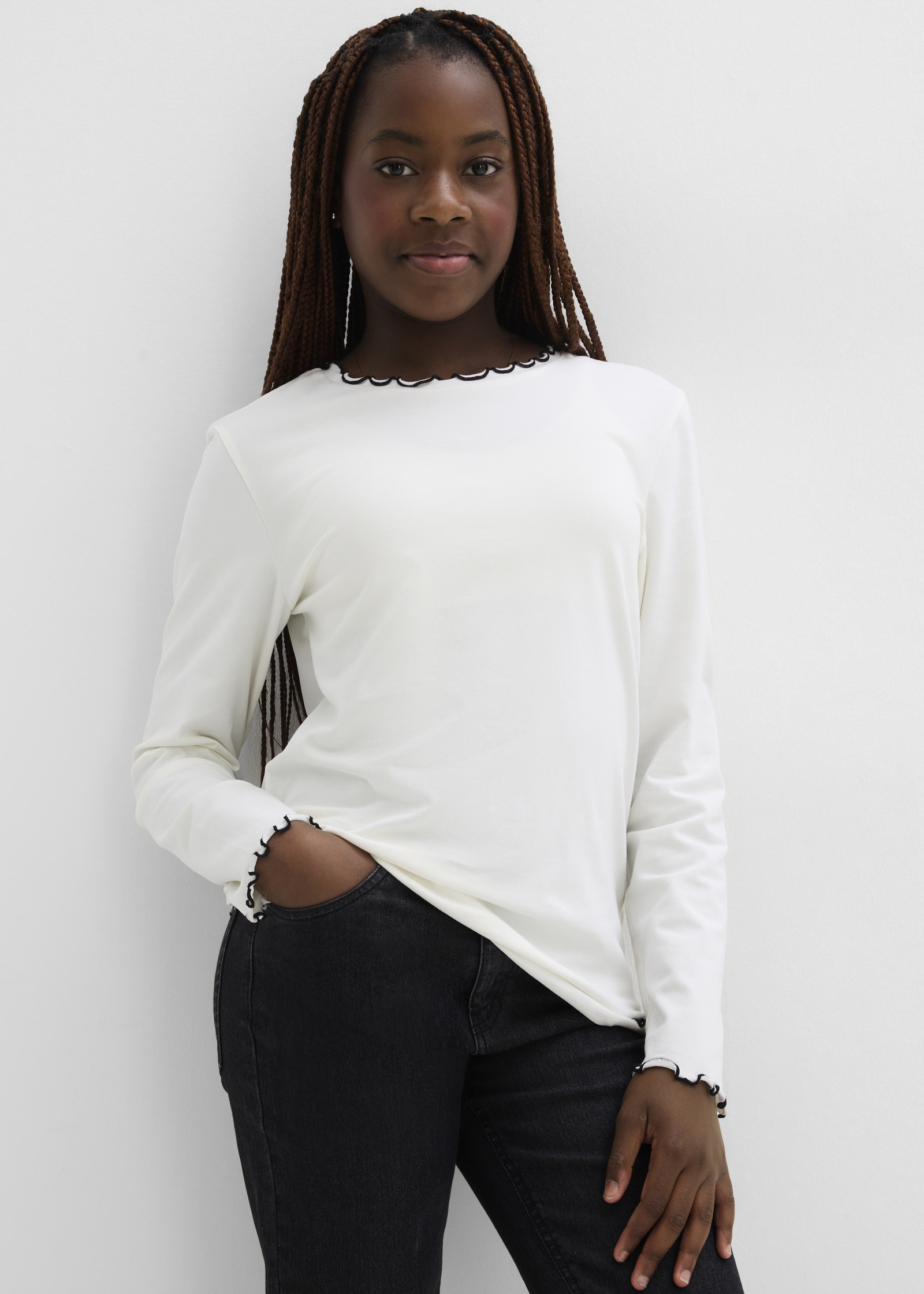 Cremeweißes Langarmshirt mit schwarzem Wellensaum.