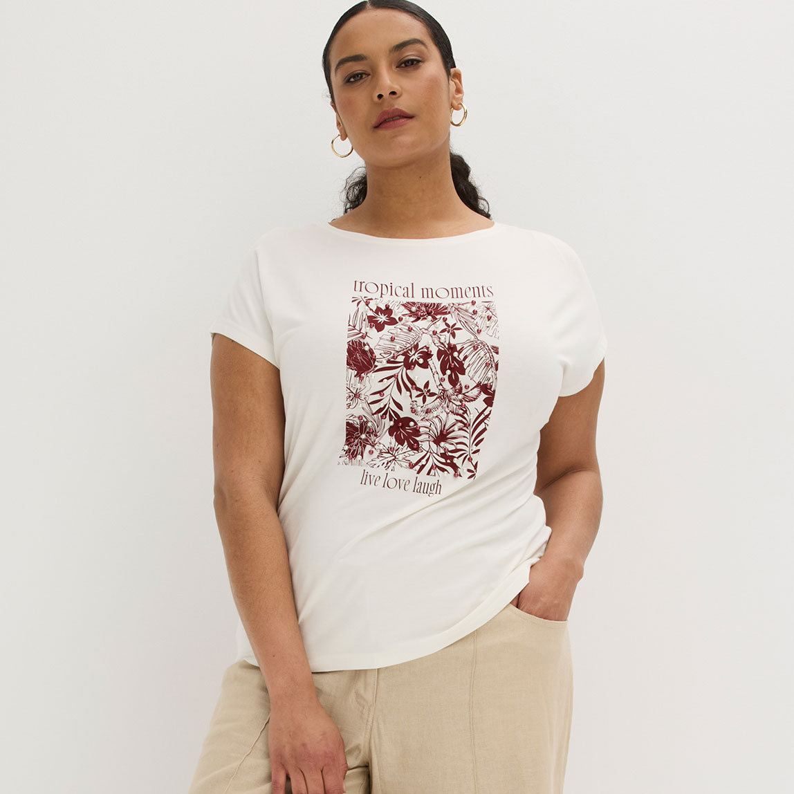 Weißes T-Shirt mit floralem Print kombiniert mit beiger Hose für einen lässigen Look.