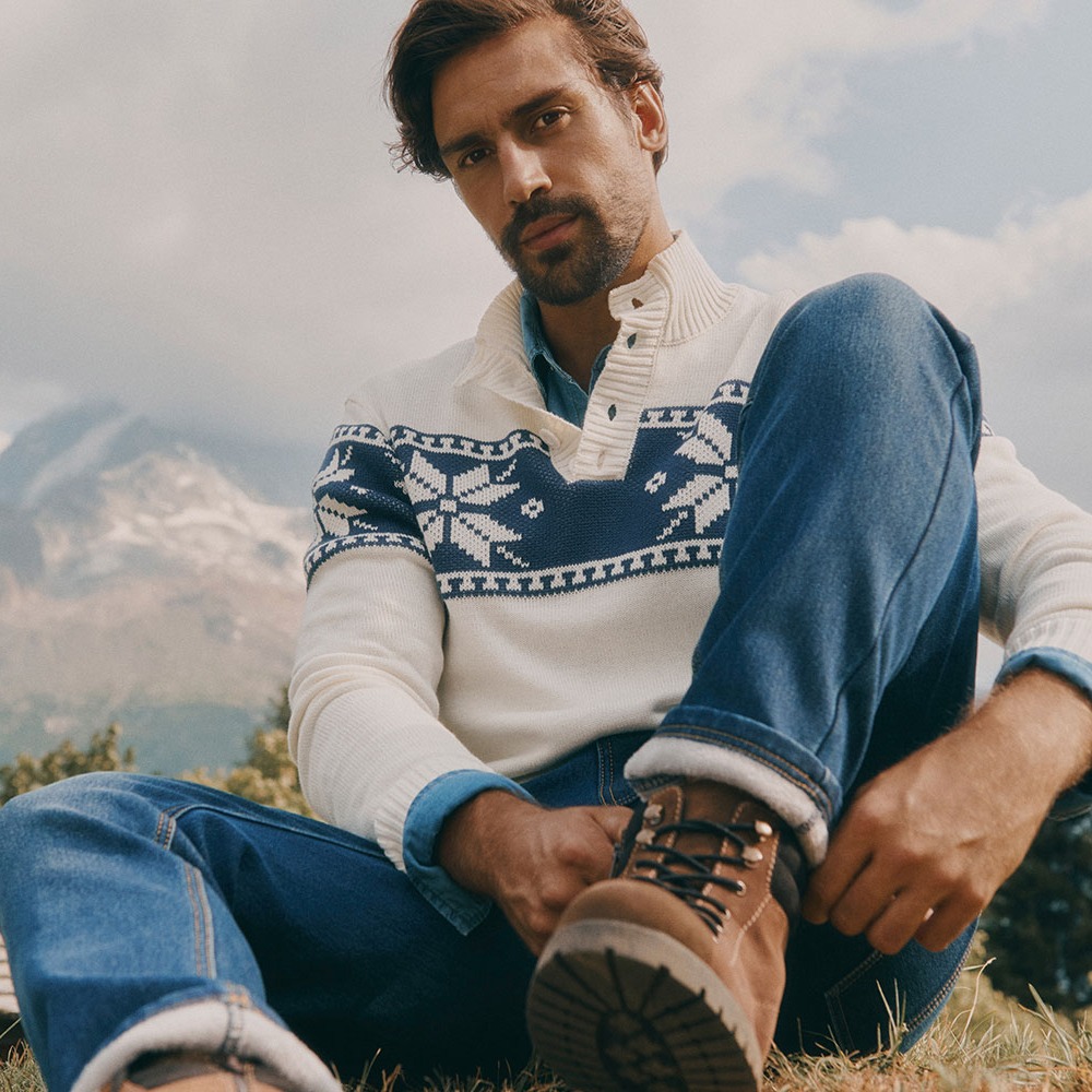 Warmer Strickpullover mit Muster, Jeans und robuste Stiefel für kalte Tage.