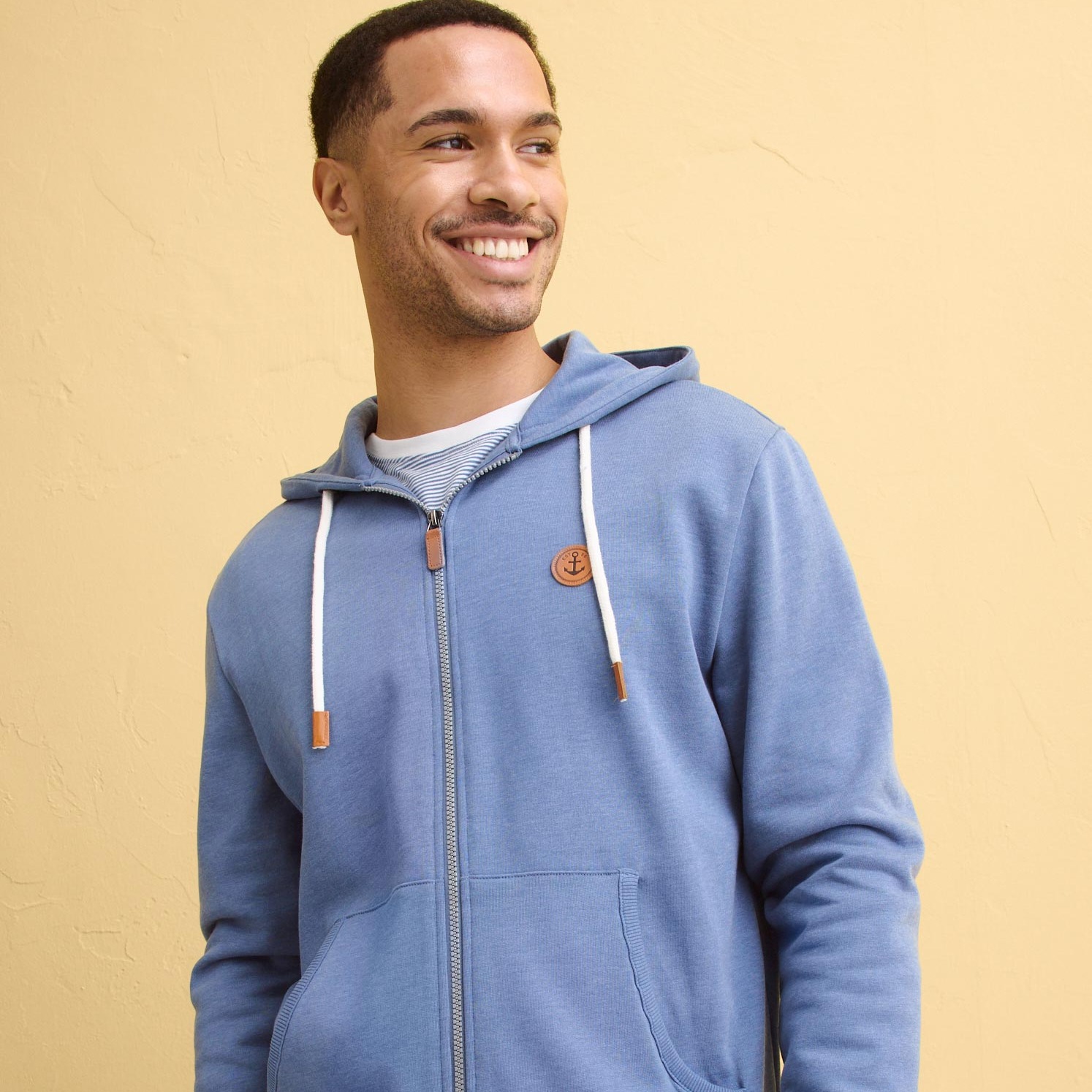 Hellblaue Kapuzenjacke mit Reißverschluss und Känguru-Tasche, kombiniert mit einer klassischen Jeans.