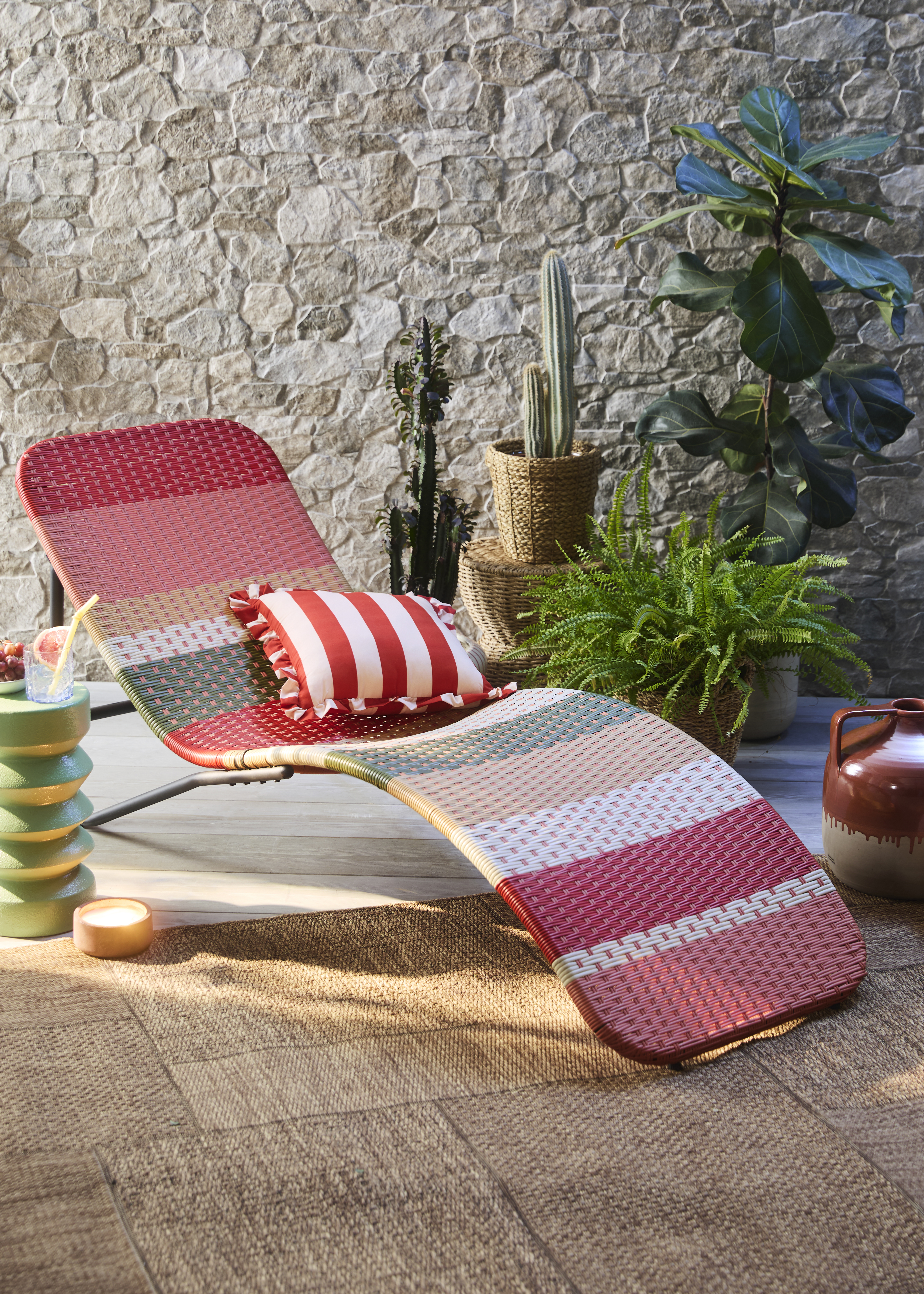 Rot-weiß gestreiftes Kissen auf Gartenstuhl, perfekt für entspannte Sommertage draußen.