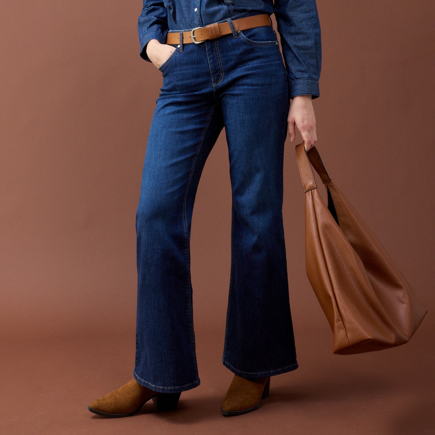 Ausgestellte Jeans, Jeanshemd und brauner Gürtel.