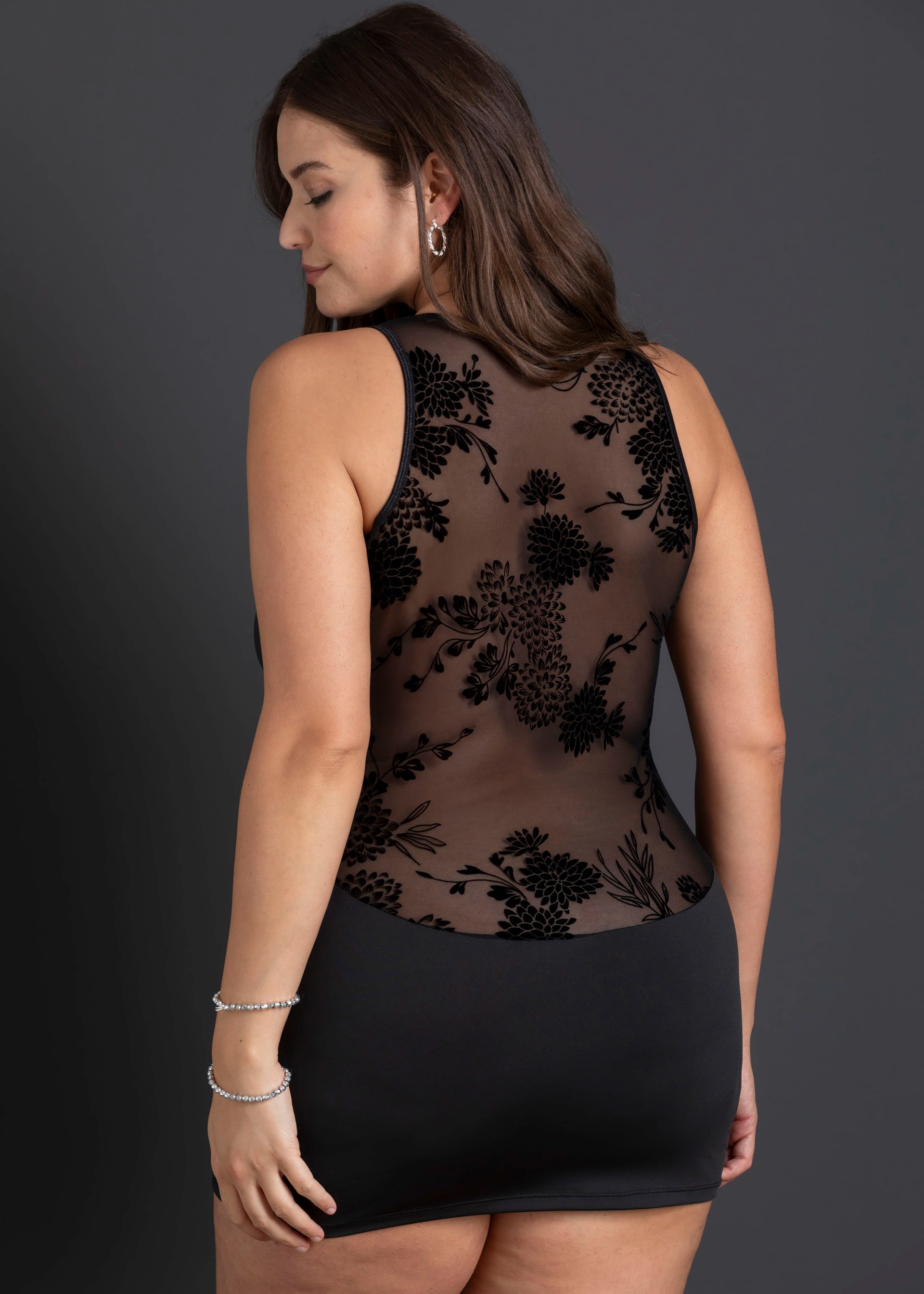 Schwarzes Minikleid mit transparentem Rücken und floralem Samtmuster, schlichtes Rockteil.