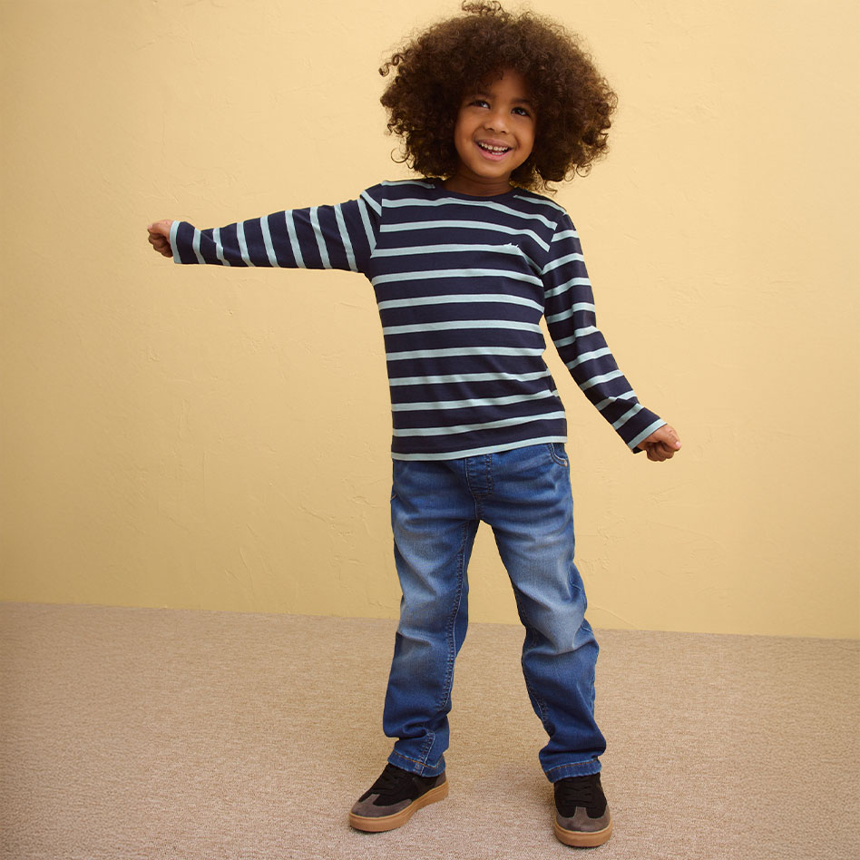 Gestreiftes Langarmshirt in Blau und Weiß, kombiniert mit Jeans.