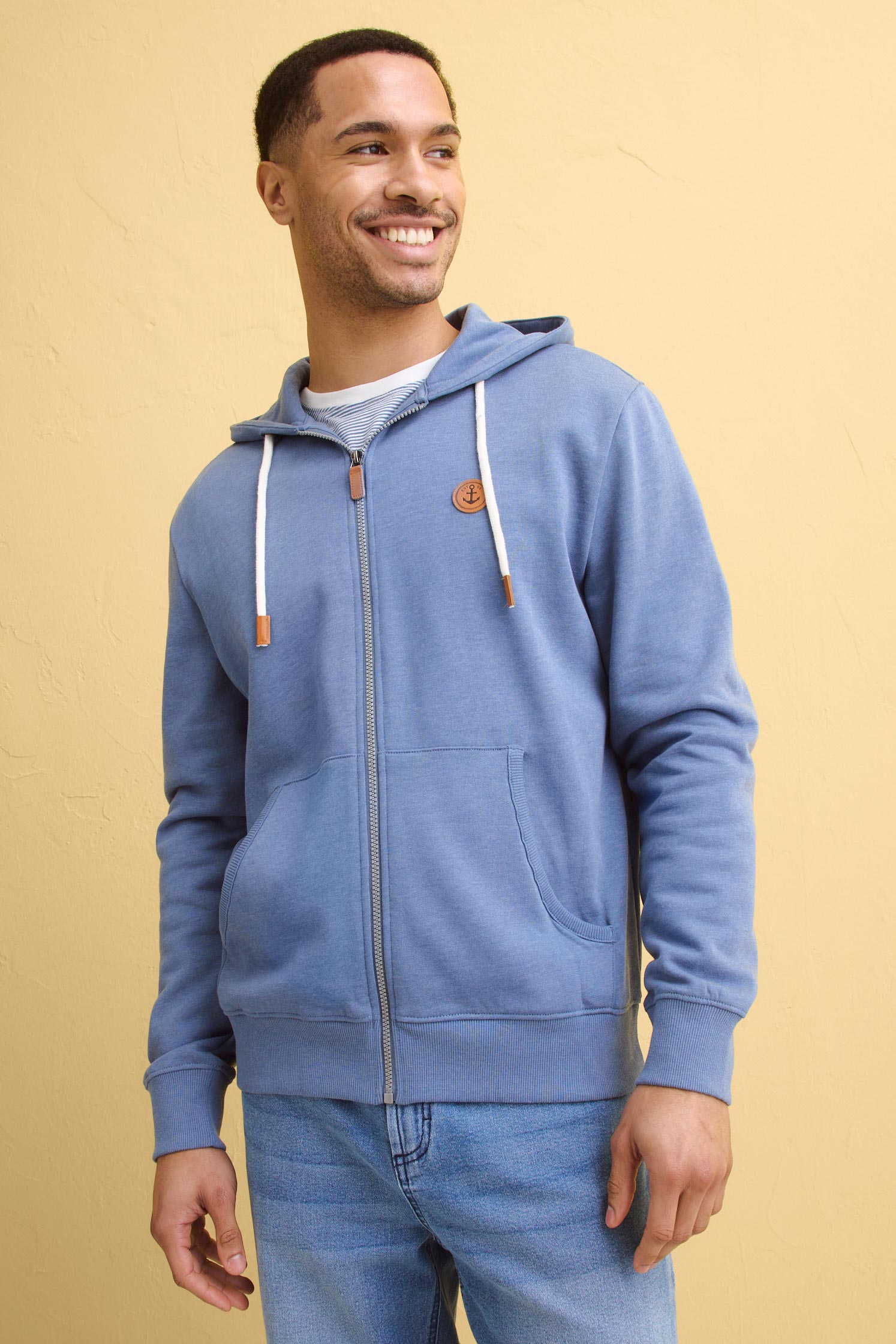 Hellblaue Kapuzenjacke mit Reißverschluss und Känguru-Tasche, kombiniert mit einer klassischen Jeans.