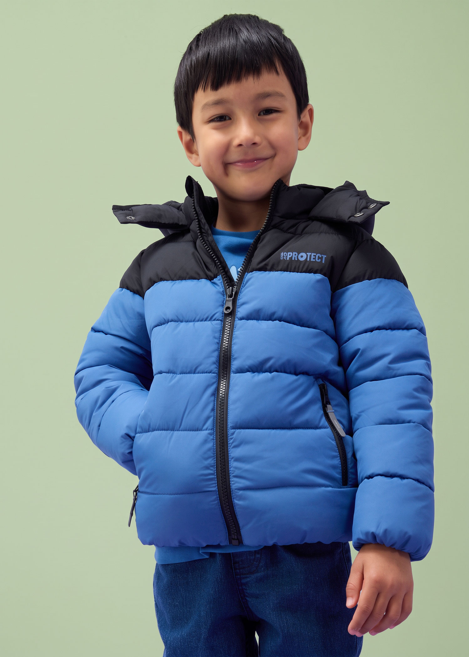 Junge trägt eine blau-schwarze Steppjacke.