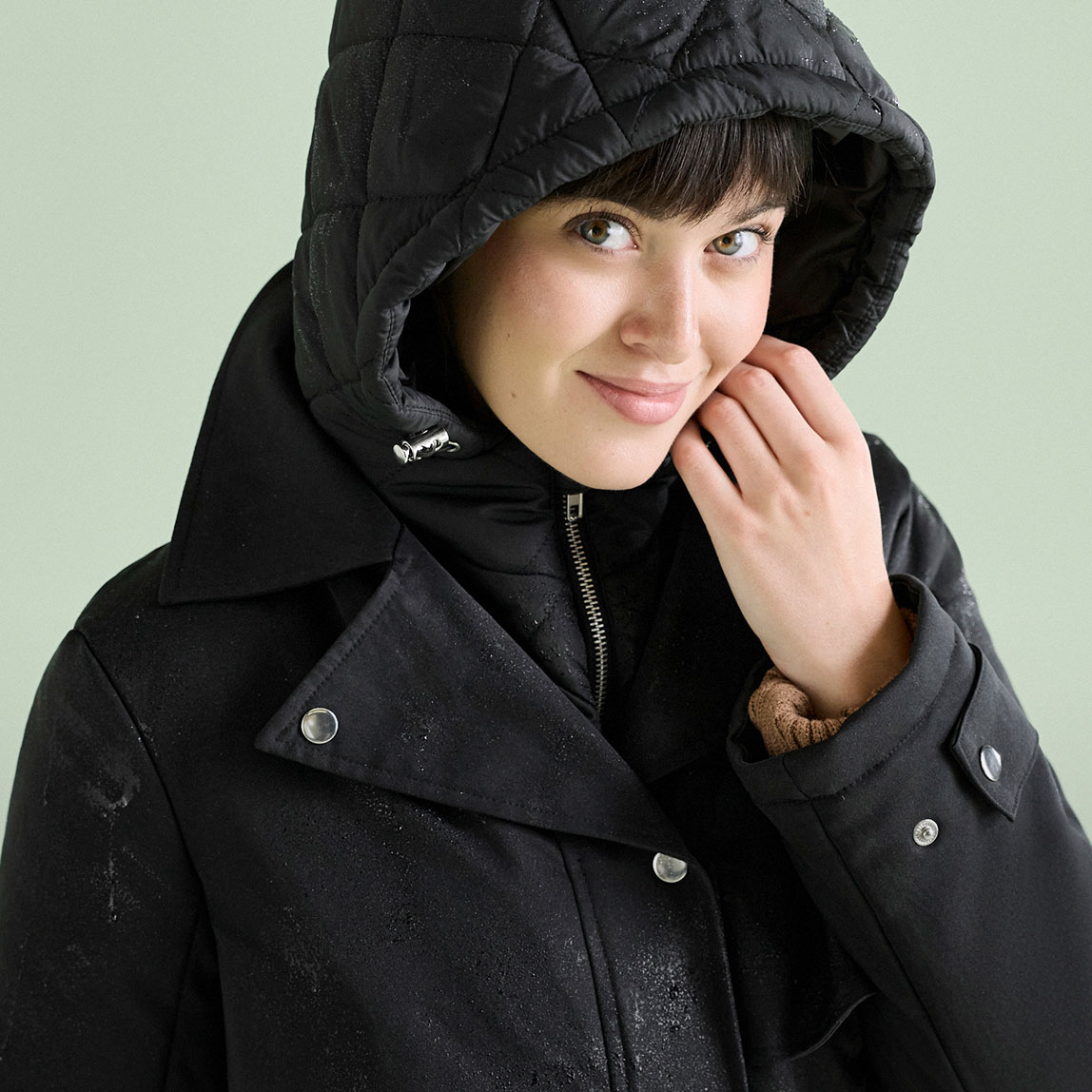 Stilvolle schwarze Doppeljacke mit gesteppter Kapuze, ideal für nasses Wetter.