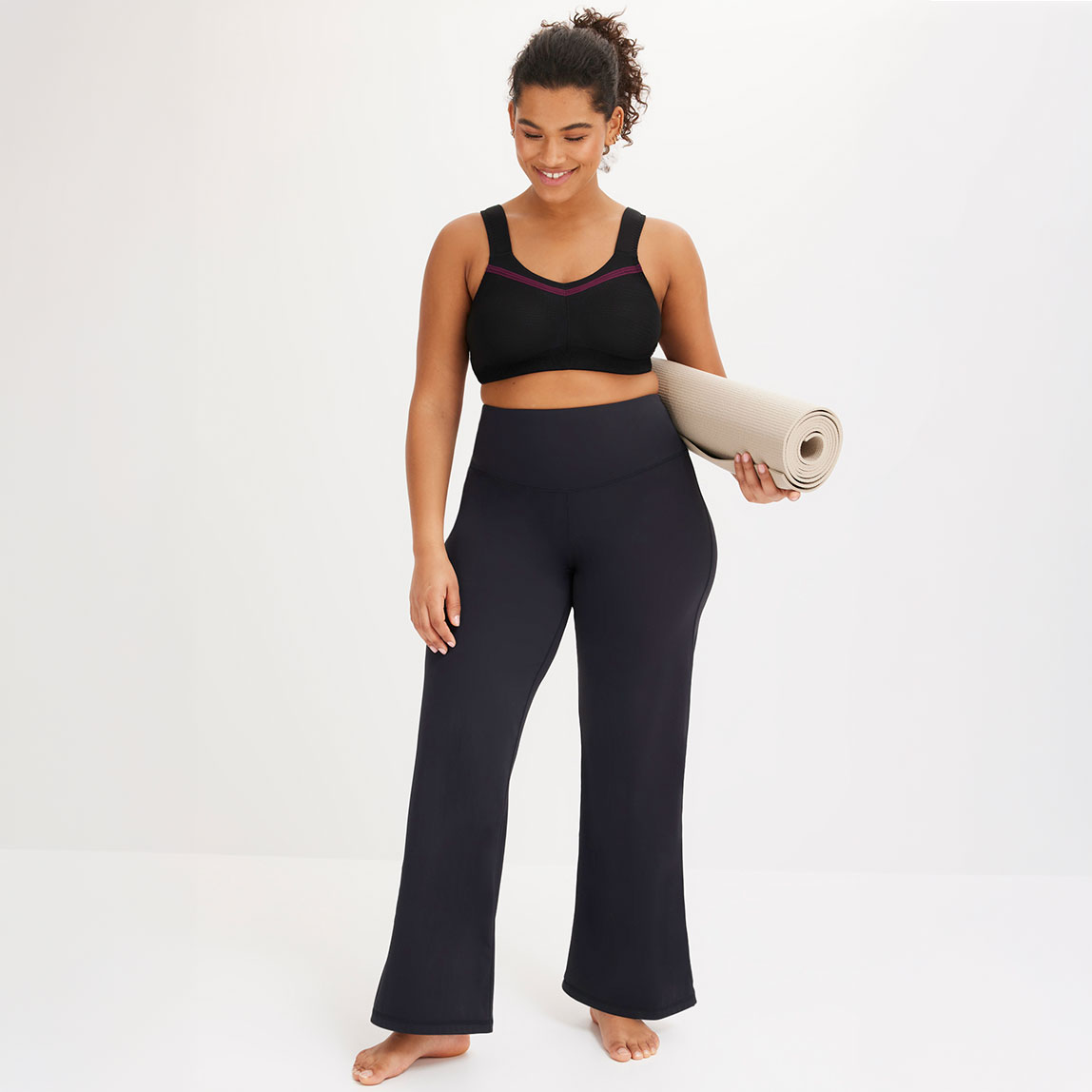 Schwarzer Sport-BH und dunkle Yogahose.