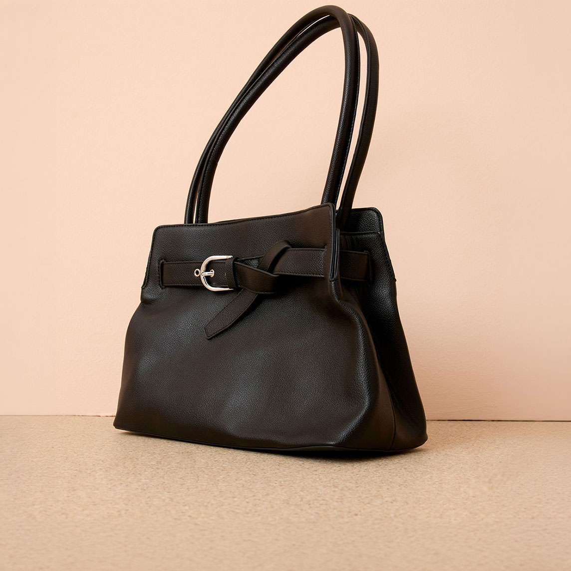 Schwarze Handtasche mit Schnalle und langen Henkeln. 