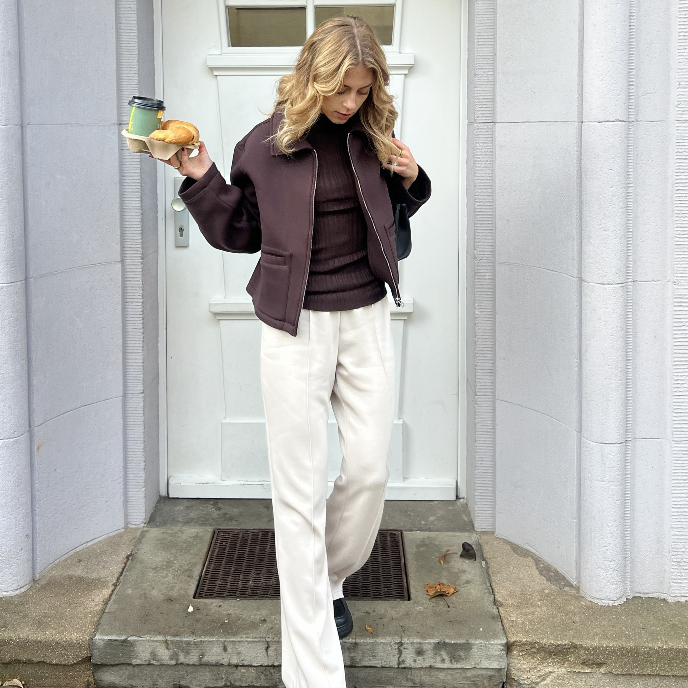 Lässiger Look mit dunkler Jacke und heller Hose. 