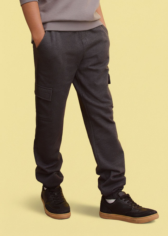 Grauer Pullover und dunkle Jogginghose.