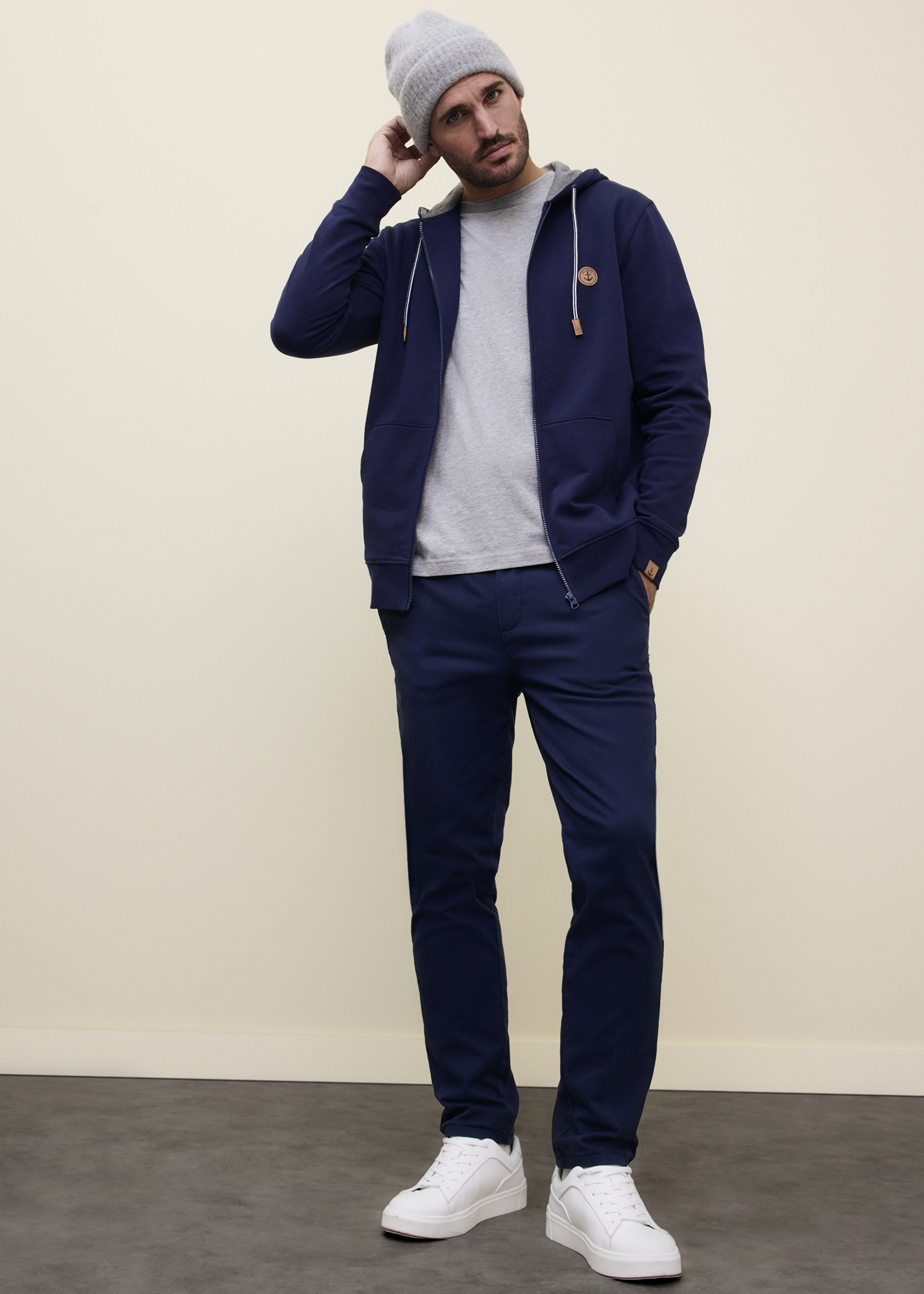 Lässiger Look mit marineblauer Kapuzenjacke, grauem Shirt & passender Hose