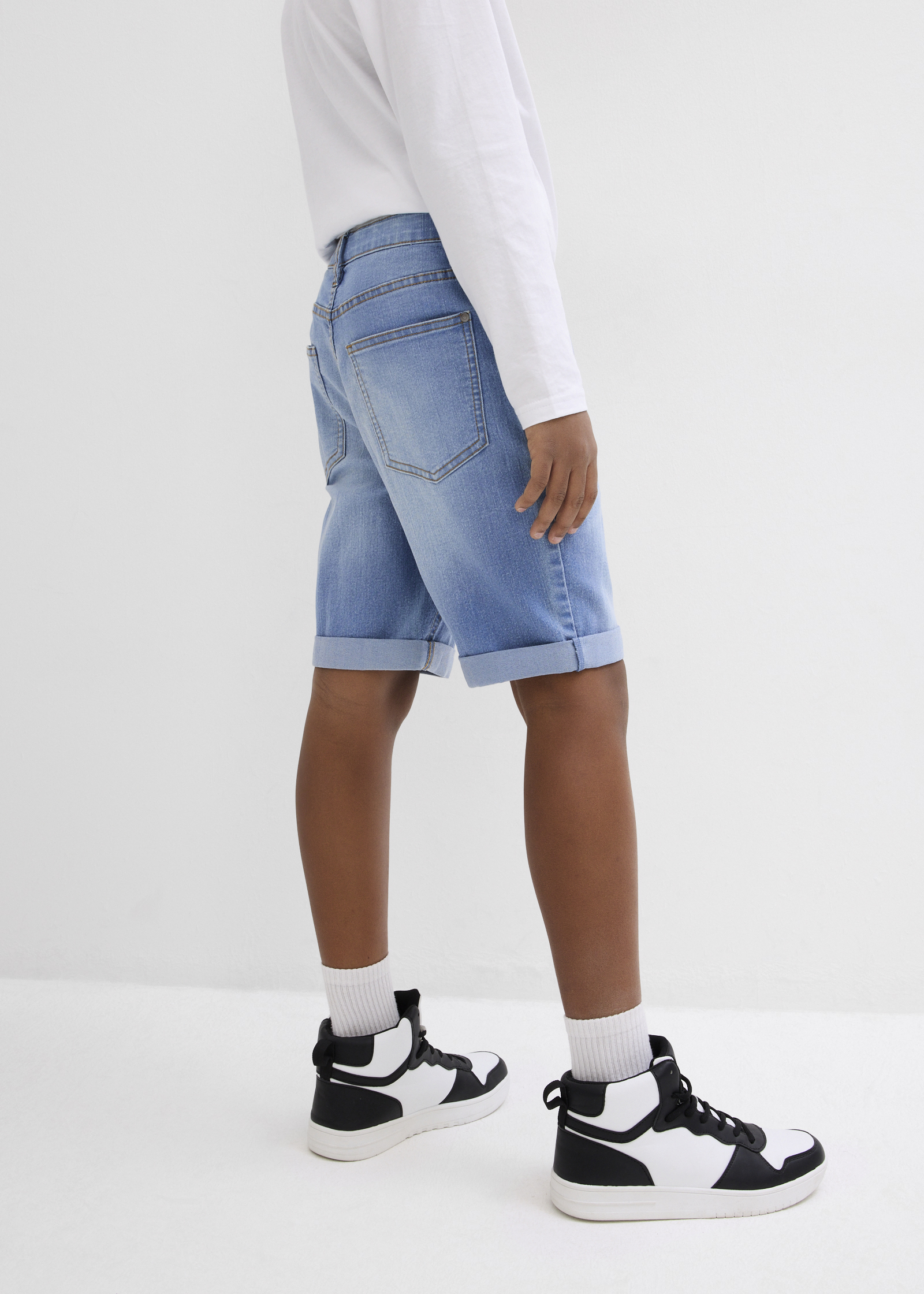 Outfit mit schwarzem Shirt und grauen Shorts.