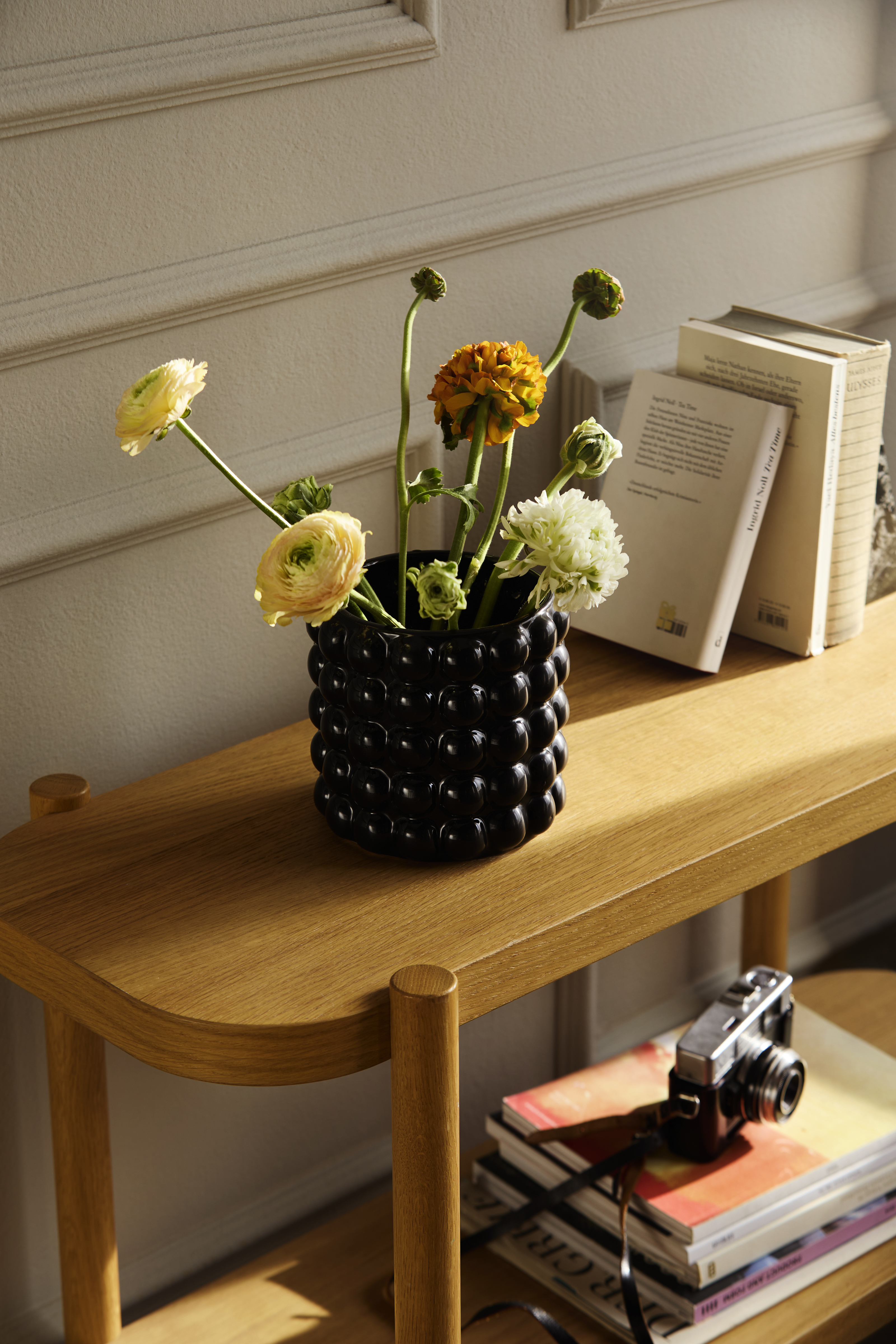 Blumen in einer Vase auf einem Holztisch.