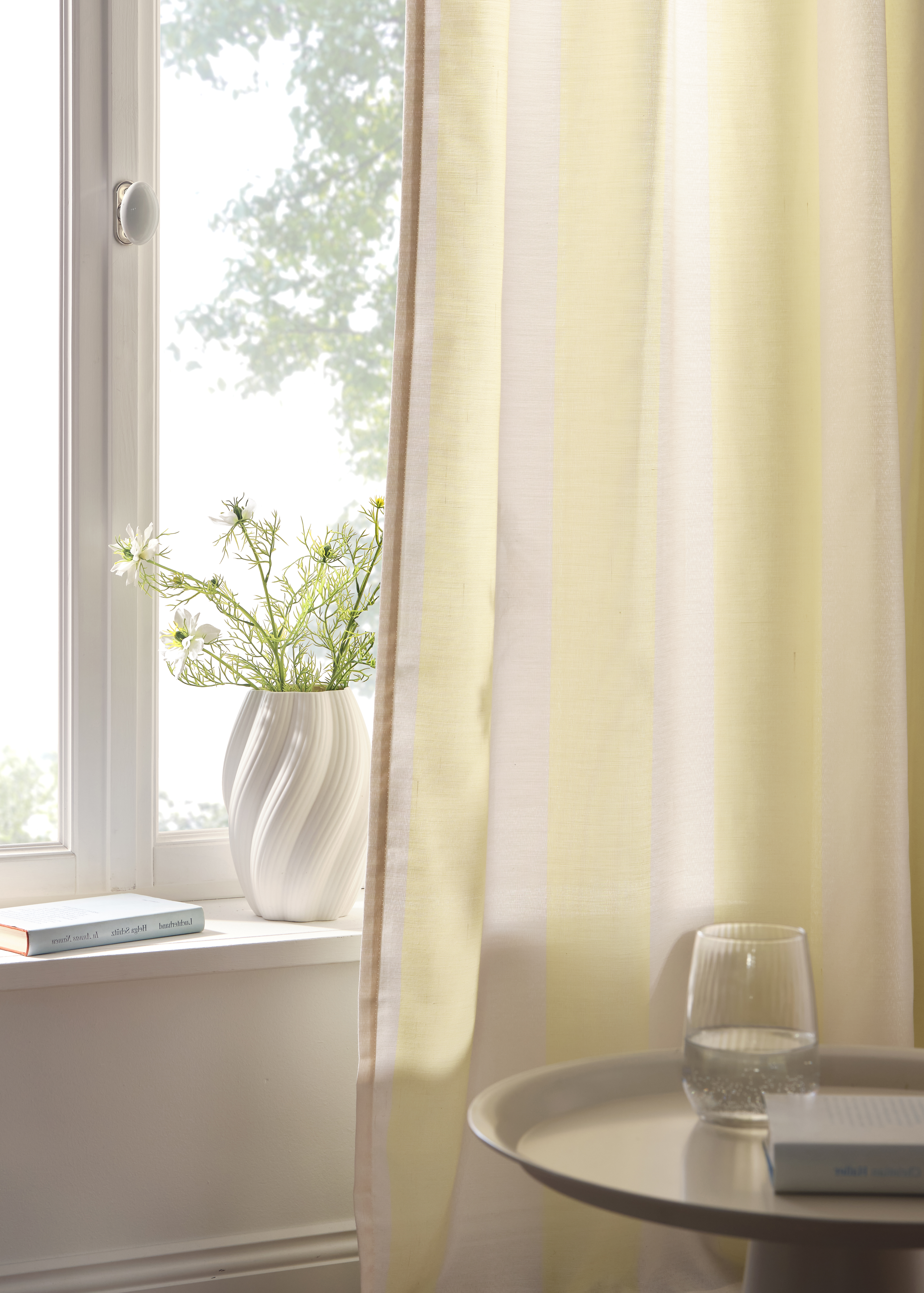 Gelbe Vorhänge vor dem Fenster.