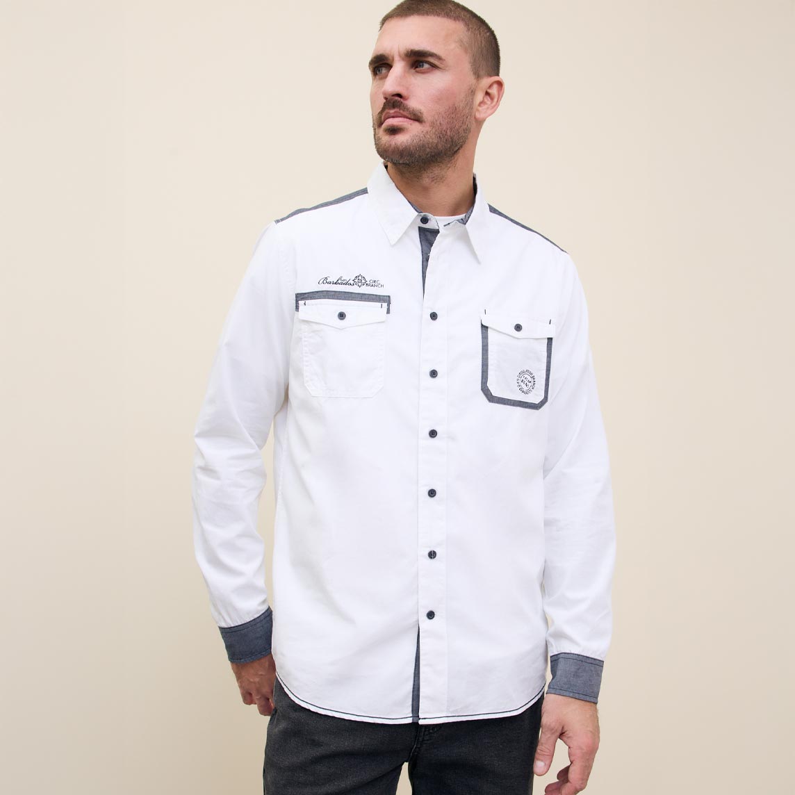 Ein weißes Hemd mit Knöpfen und Brusttaschen.