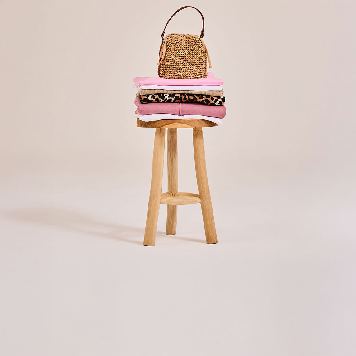 Sommerliche Strandtasche aus Stroh mit Sonnenbrille ruht auf Holzsteg am idyllischen See.