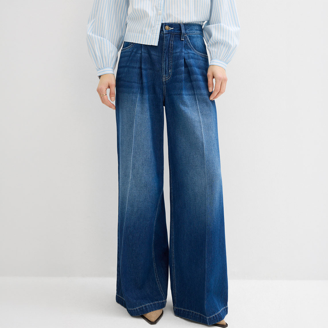 Weites Bein trifft auf blauen Denim und gestreifte Bluse.