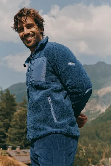 Dunkelblaue Fleecejacke mit Brusttasche und bequeme Kordhose, perfekt für Outdoor-Abenteuer.