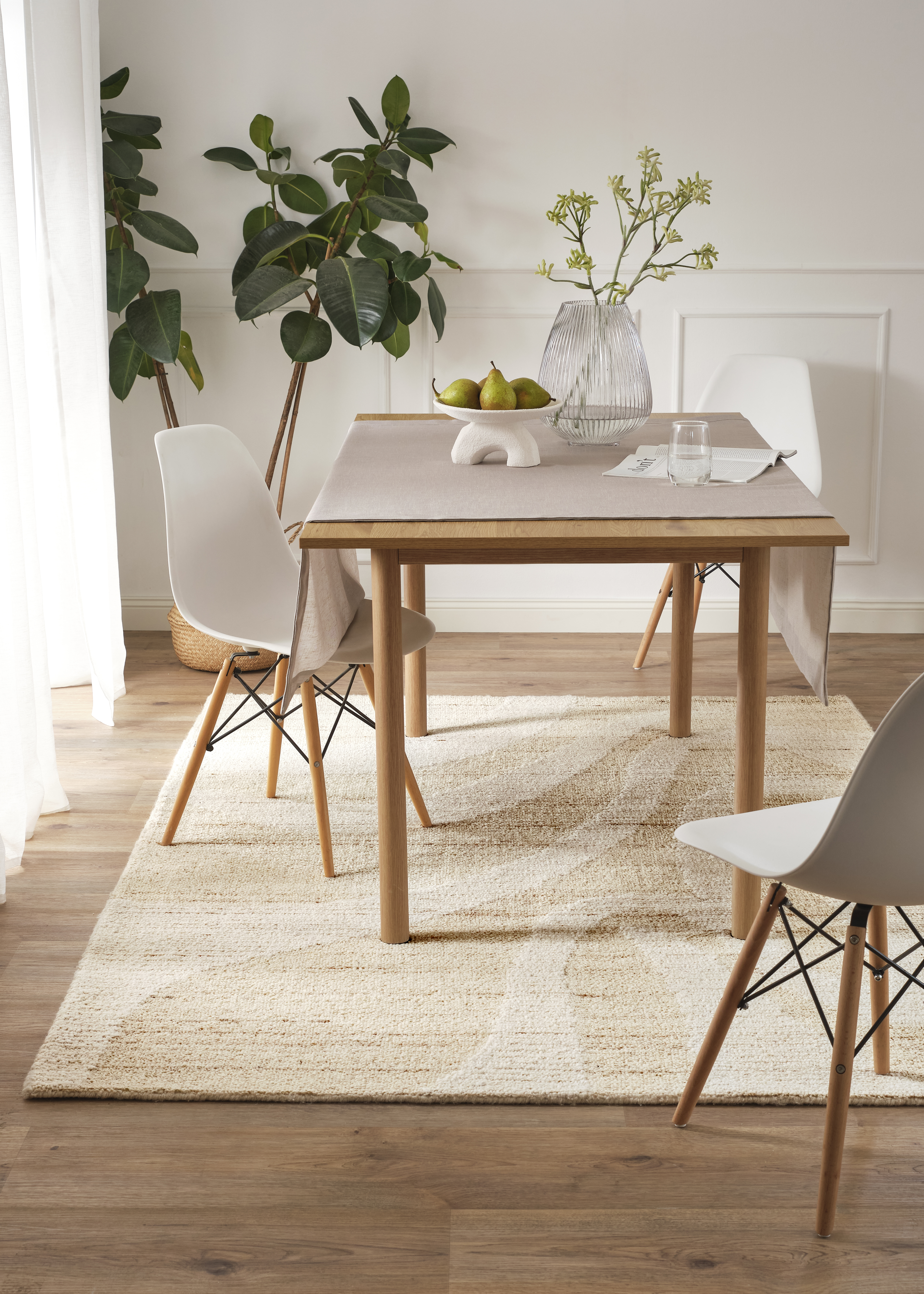 Moderne weiße Stühle mit Holzbeinen ergänzen den schlichten Esstisch im minimalistischen Esszimmer.