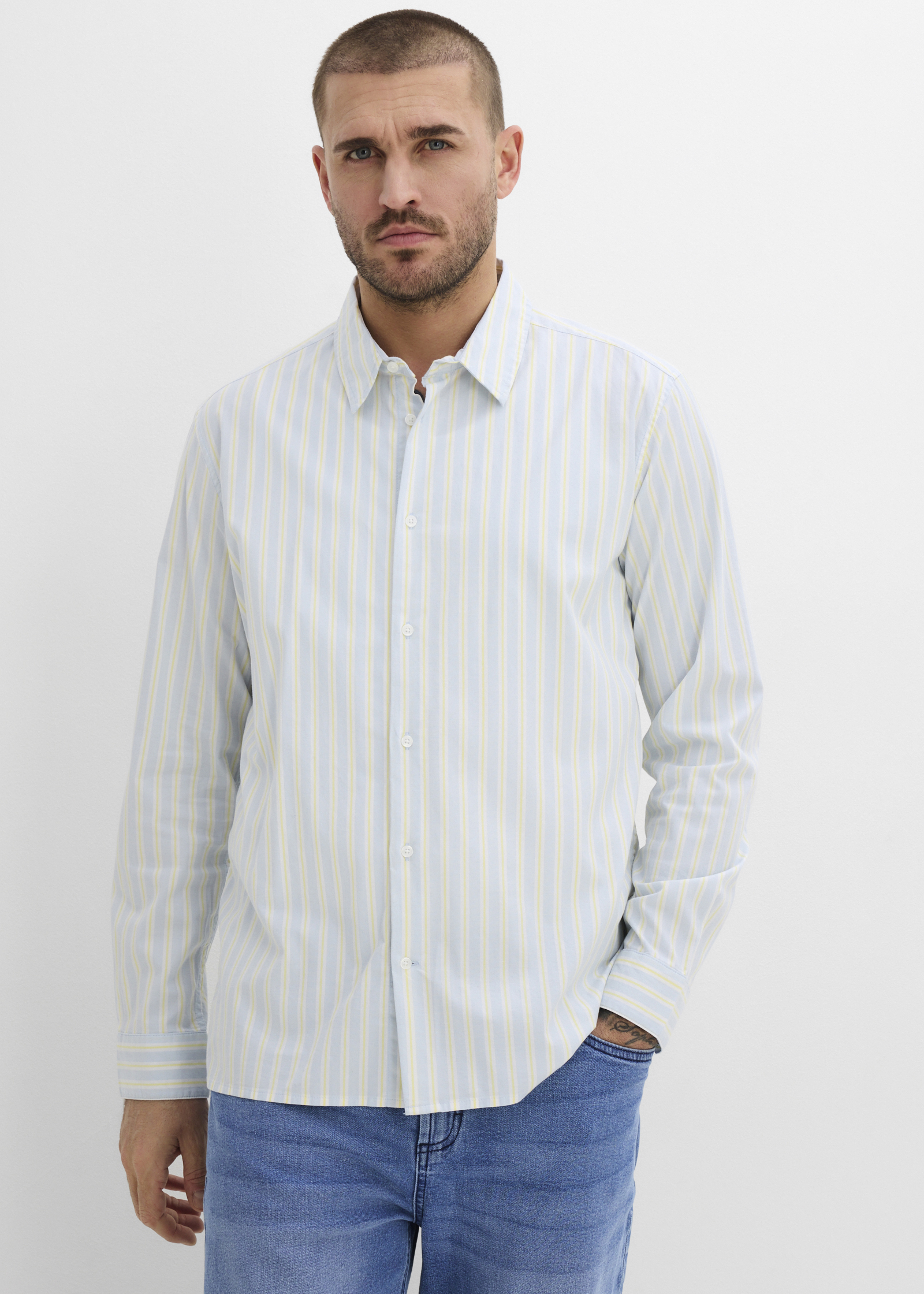 Gestreiftes Hemd in Hellblau und Beige, kombiniert mit lässiger Jeans.