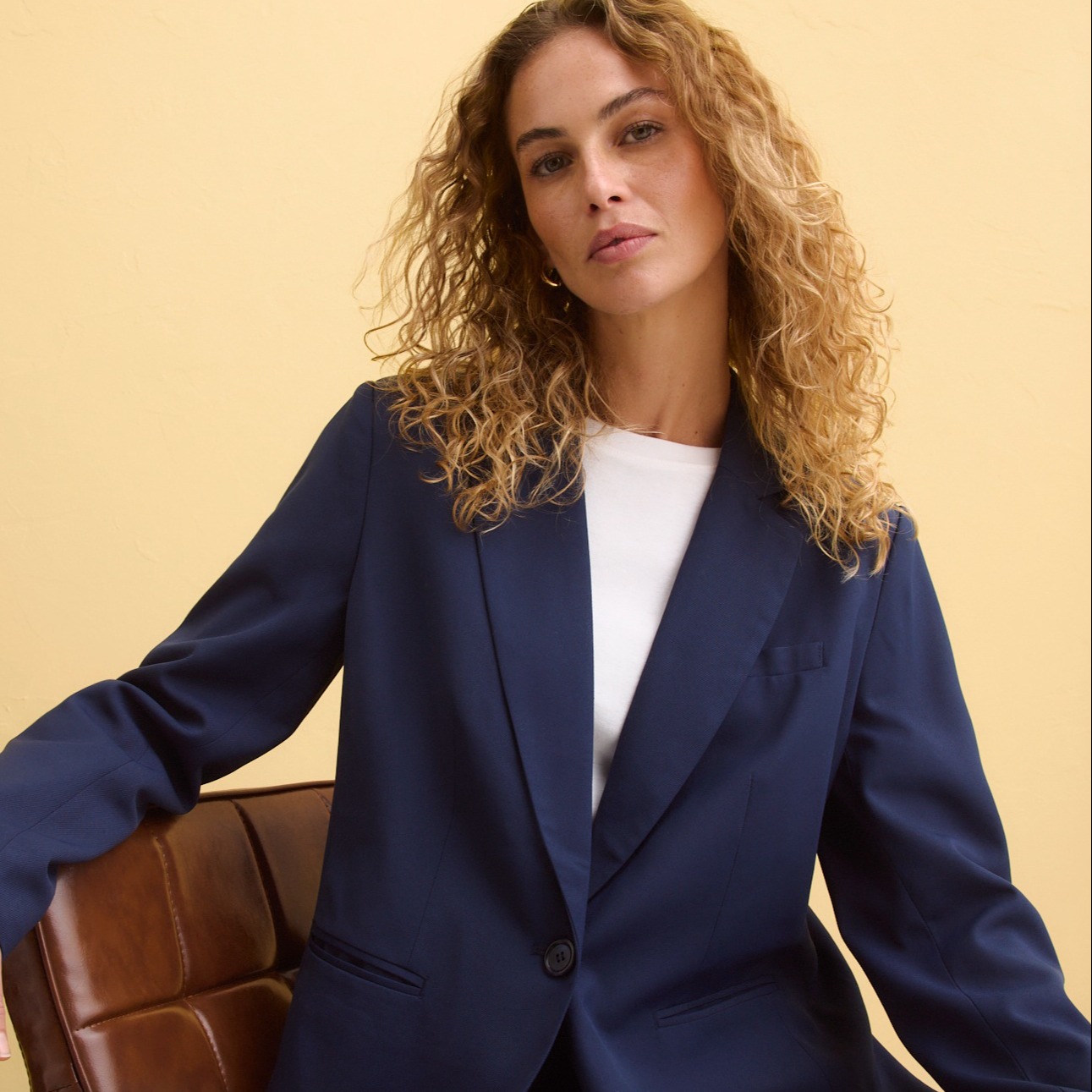 Eleganter dunkelblauer Hosenanzug mit weißem Oberteil. Klassischer Blazer und weite Hose für einen stilvollen Look.