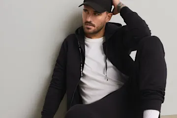 Schwarze Kappe, Hoodie, weißes T-Shirt und bequeme Jogginghose für einen lässigen Look.