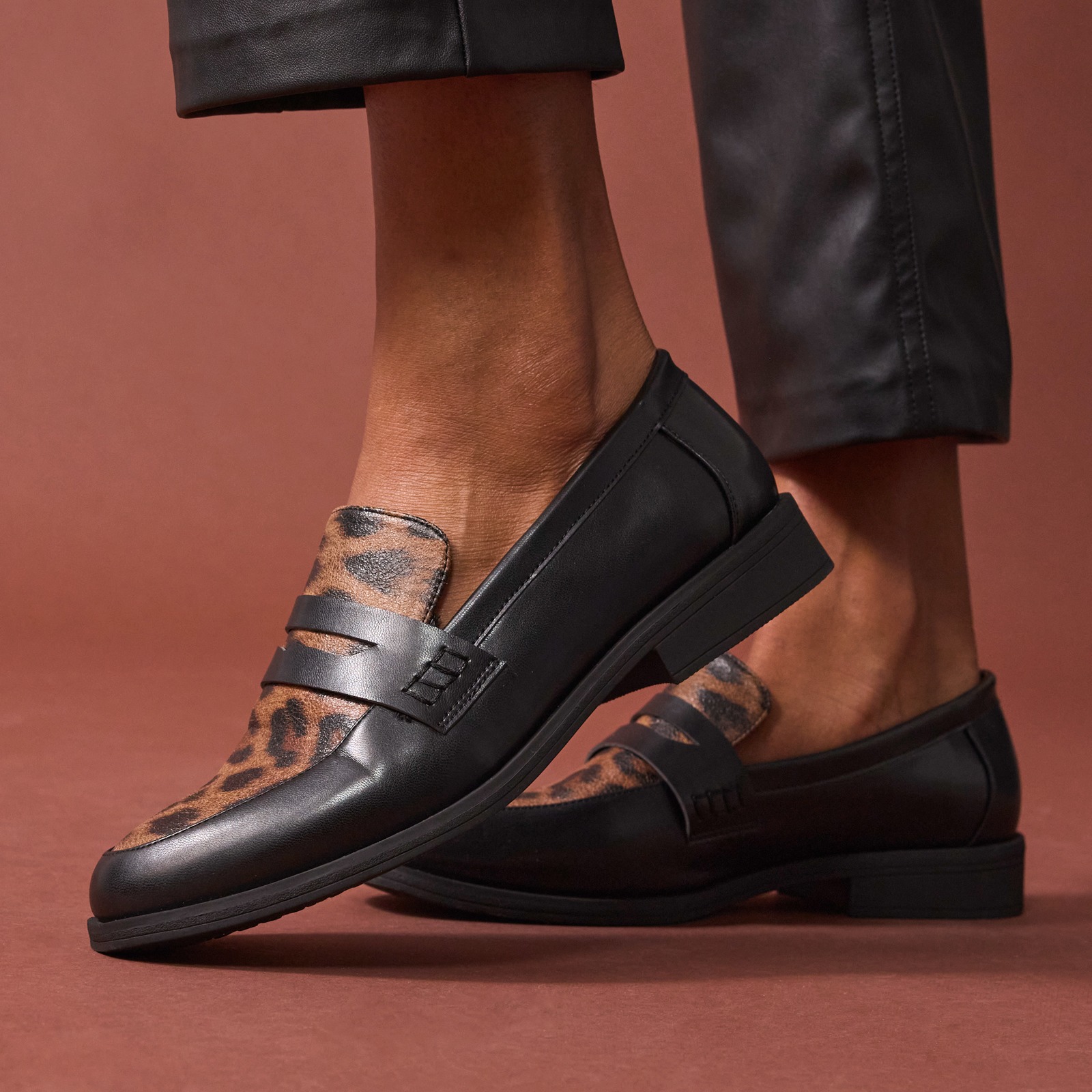 Schwarze Sneaker mit weißen Streifen und weiße Socken mit Herzchen.