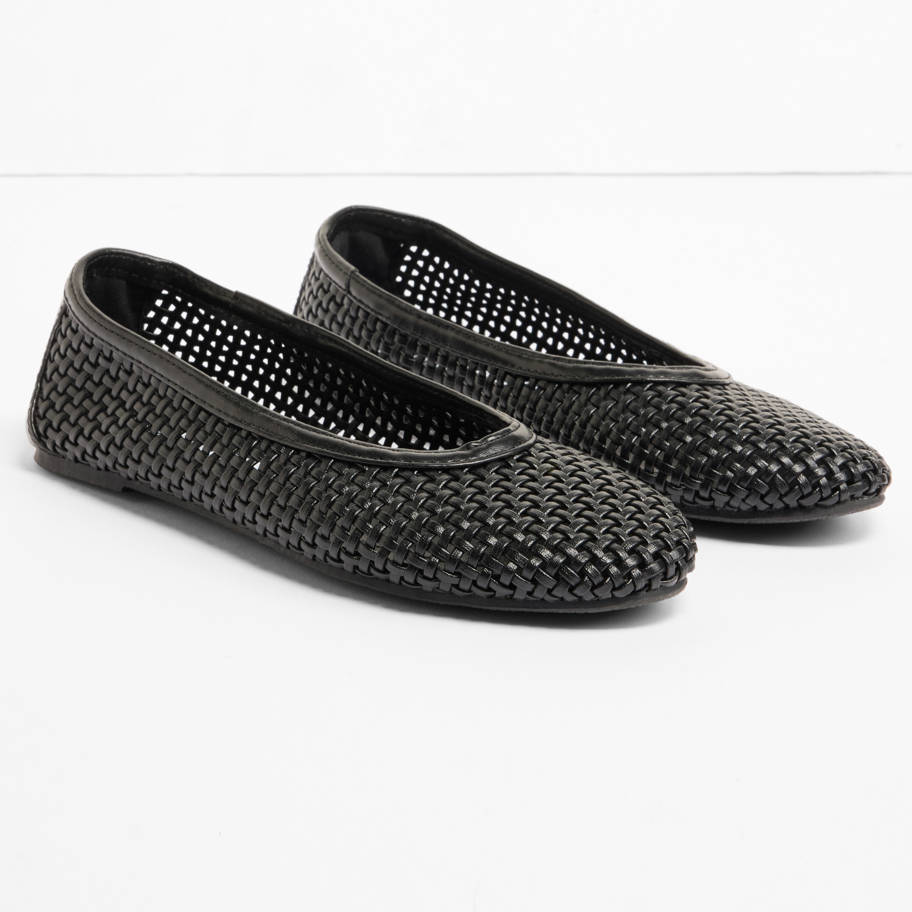 Schwarze Ballerinas mit dekorativem Lochmuster für einen eleganten, luftigen Look.