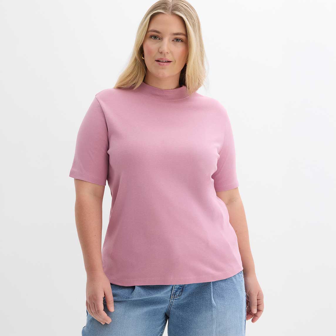 Rosa T-Shirt mit kurzem Ärmel und Rundhalsausschnitt, kombiniert mit hellblauer Jeans.