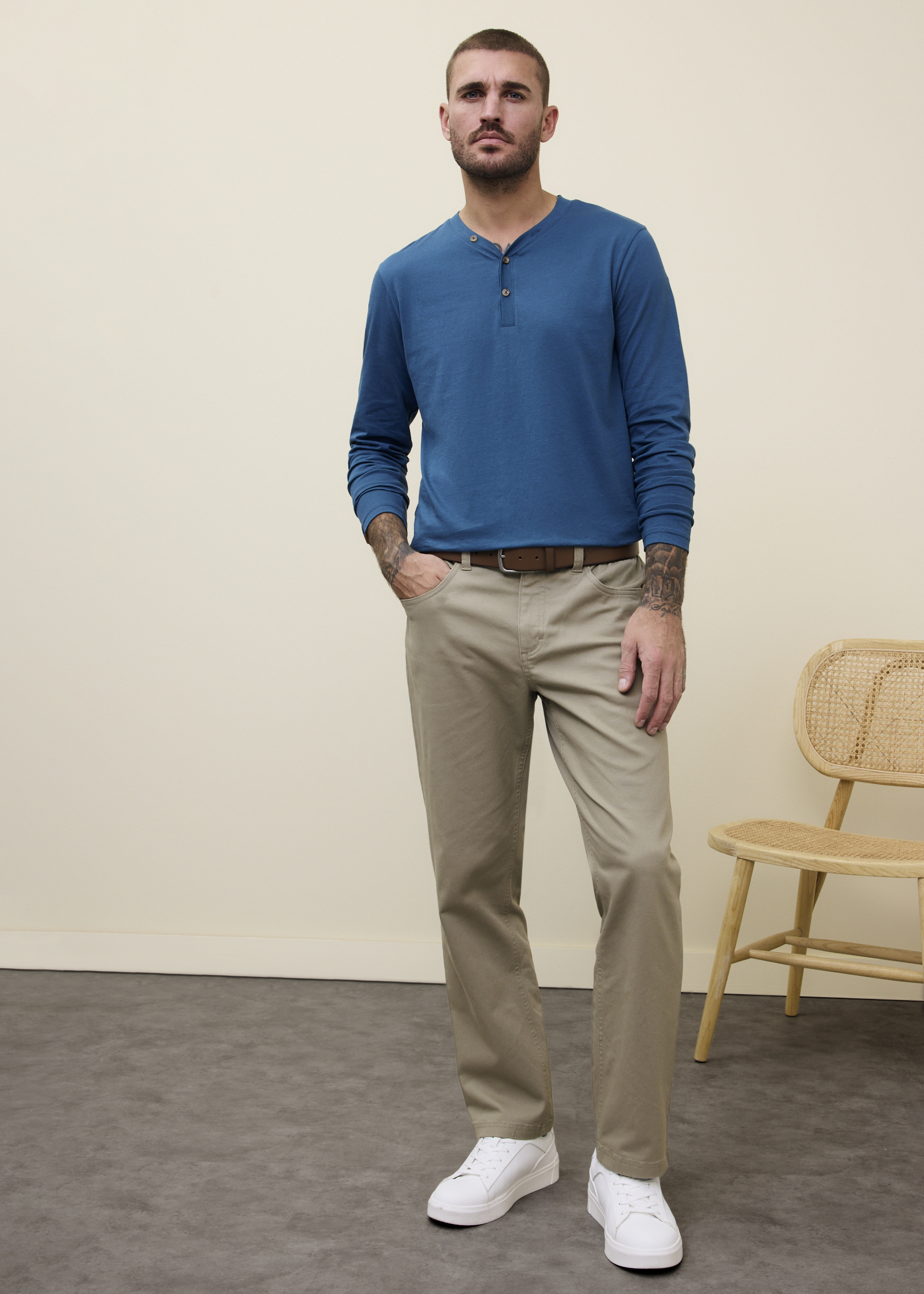 Blaues Langarmshirt, beige Hose und weiße Sneaker.