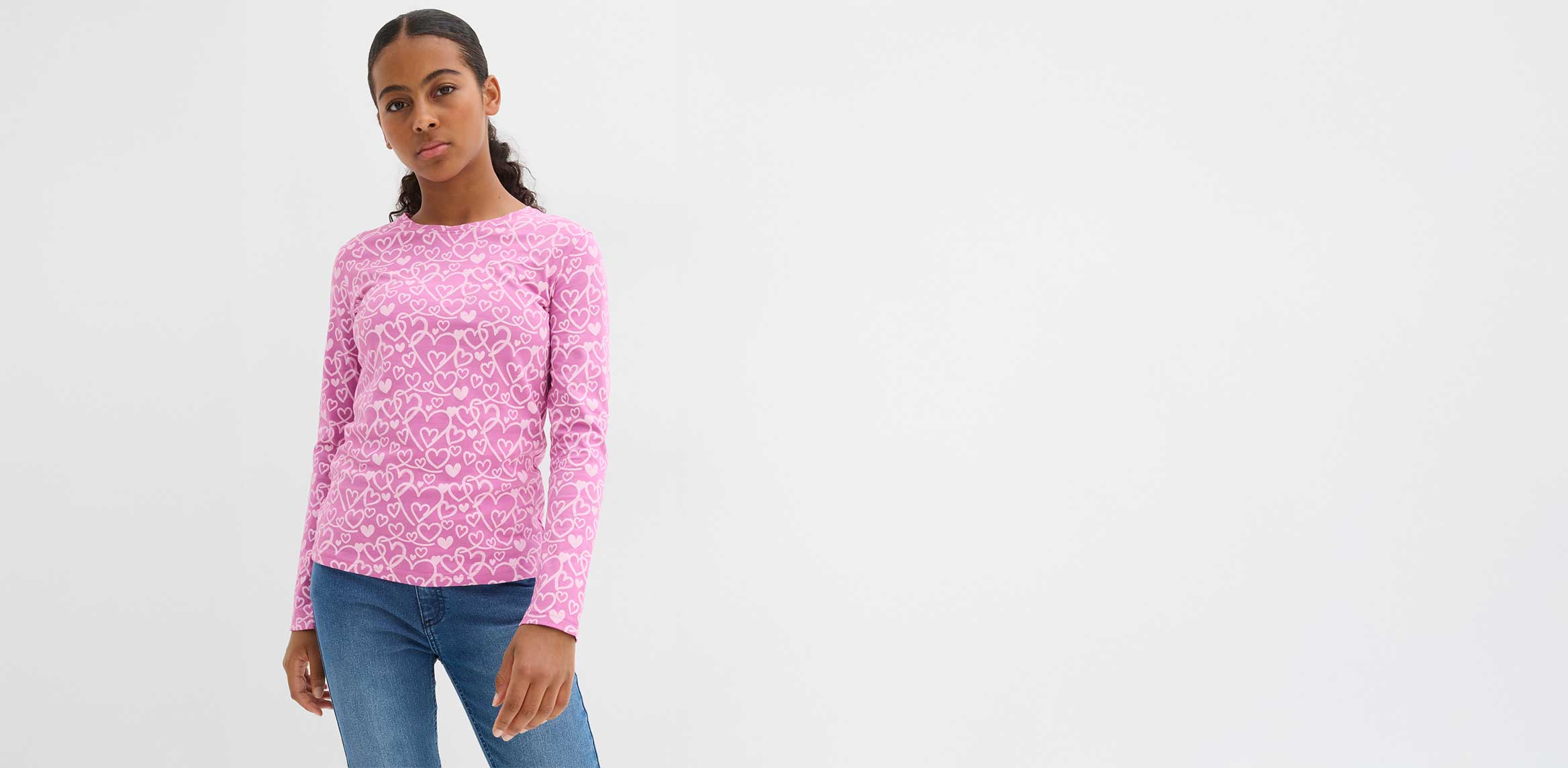 Rosa Pullover mit weißem Leopardenmuster, blaue Jeans. Lässiger Look für den Alltag.