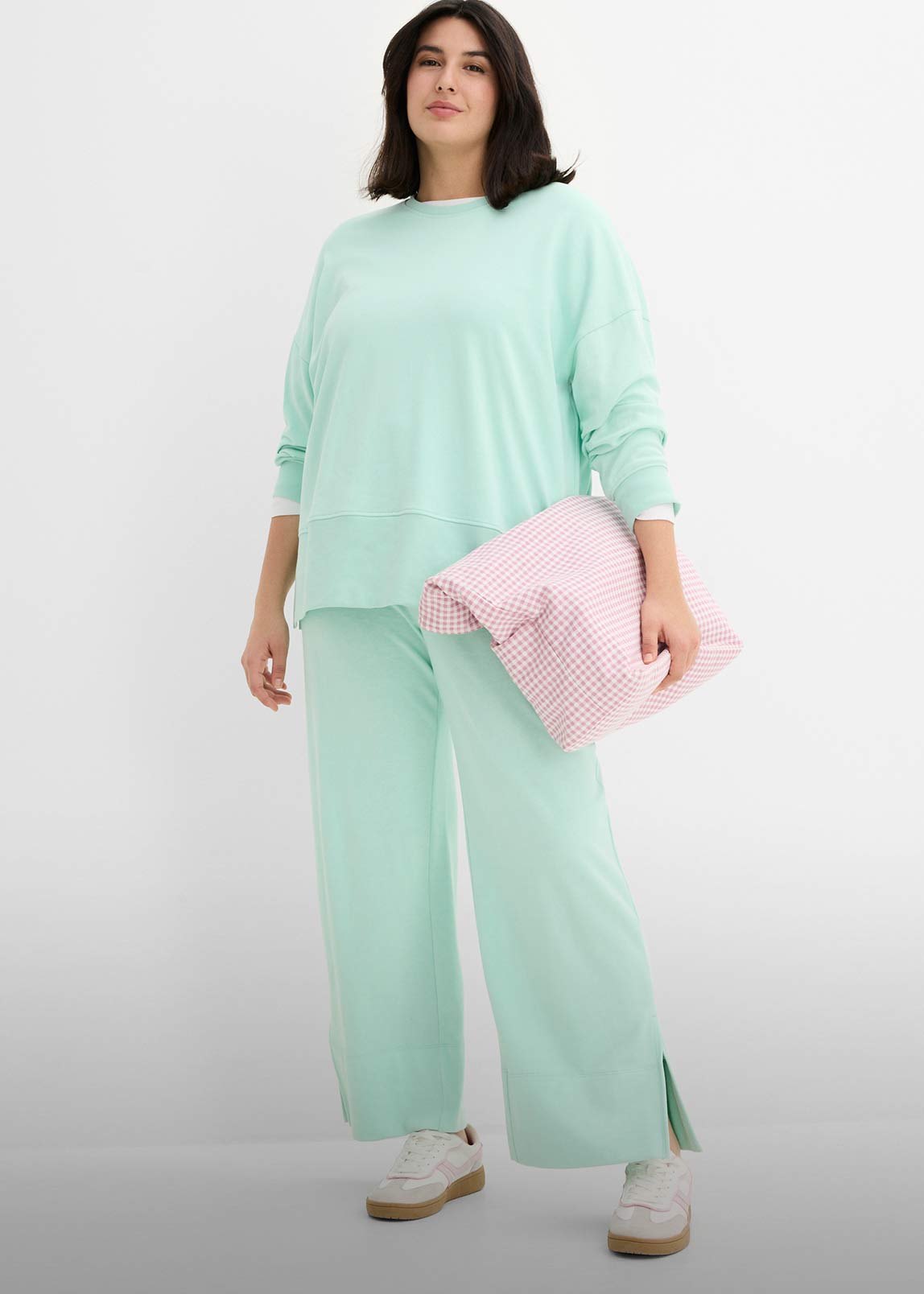 Bequemer mintgrüner Freizeitanzug mit weitem Pullover und Hose. 