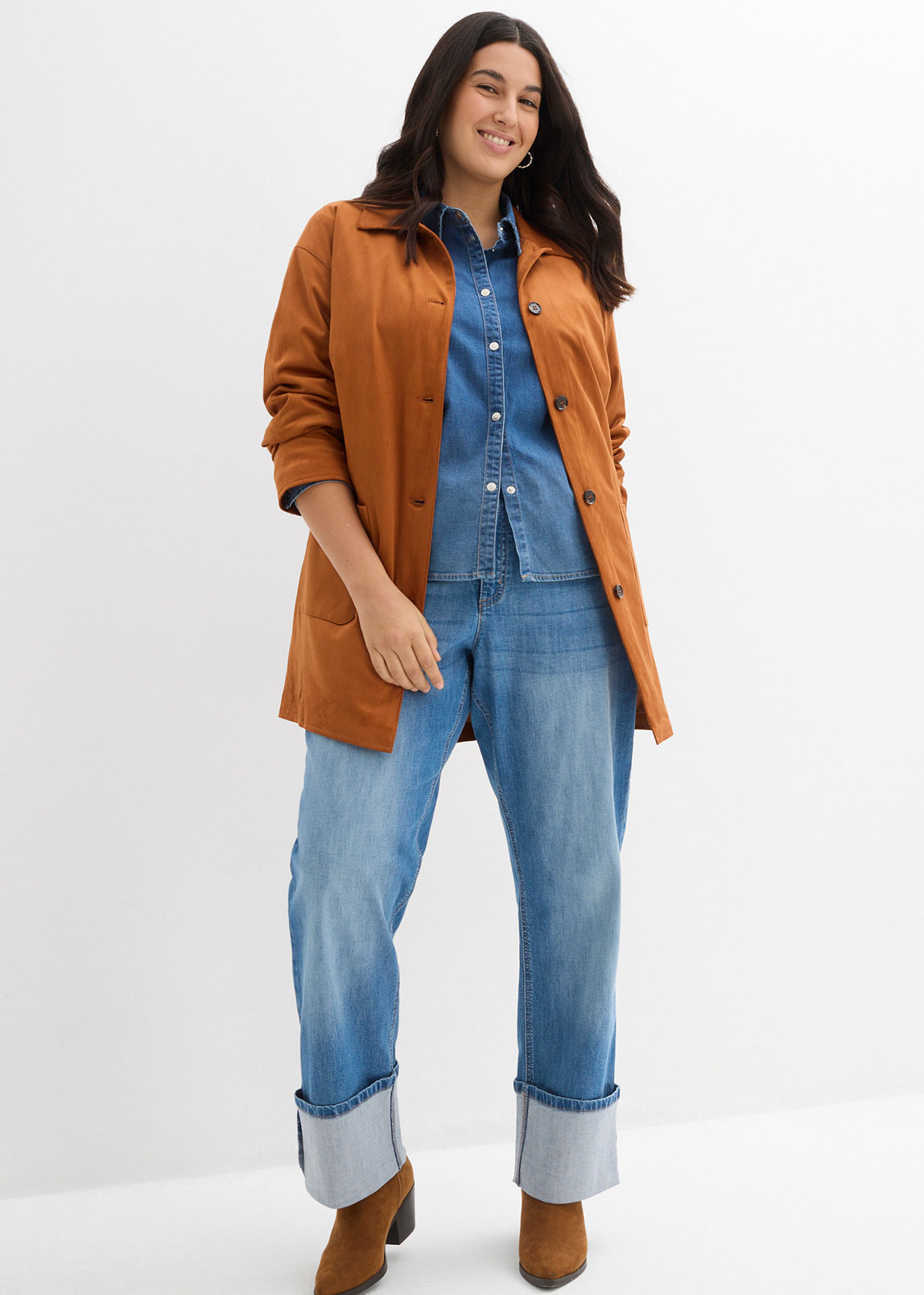 Braune Jacke über Jeanshemd und weiten Jeans mit Umschlag.