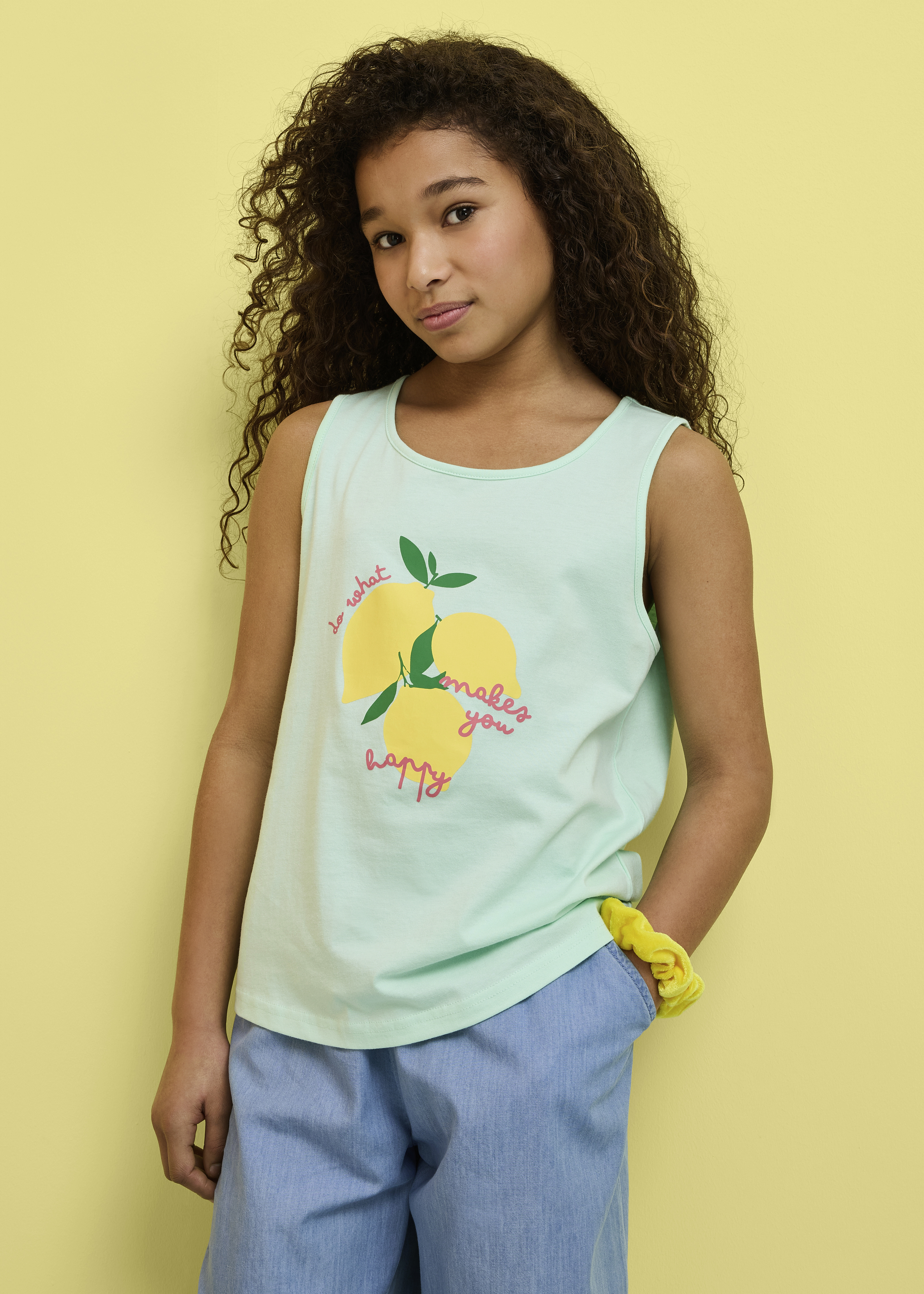 Mintgrünes Zitronen-Tanktop und hellblaue Hose, ergänzt durch ein gelbes Scrunchie.