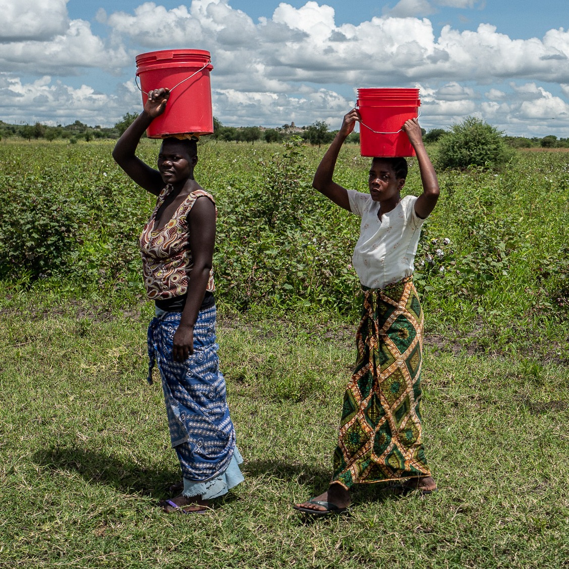 Bunte Kleidung auf dem Feld: Gemusterte Röcke und einfache Oberteile bei der Arbeit.