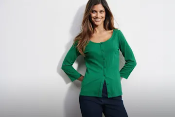 Grüner Strickcardigan mit Knopfleiste und dazu schlichte, dunkelblaue Jeans.