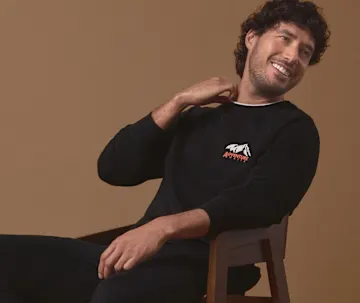 Ein gemütliches schwarzes Langarmshirt mit Berglogo und eine passende Hose.