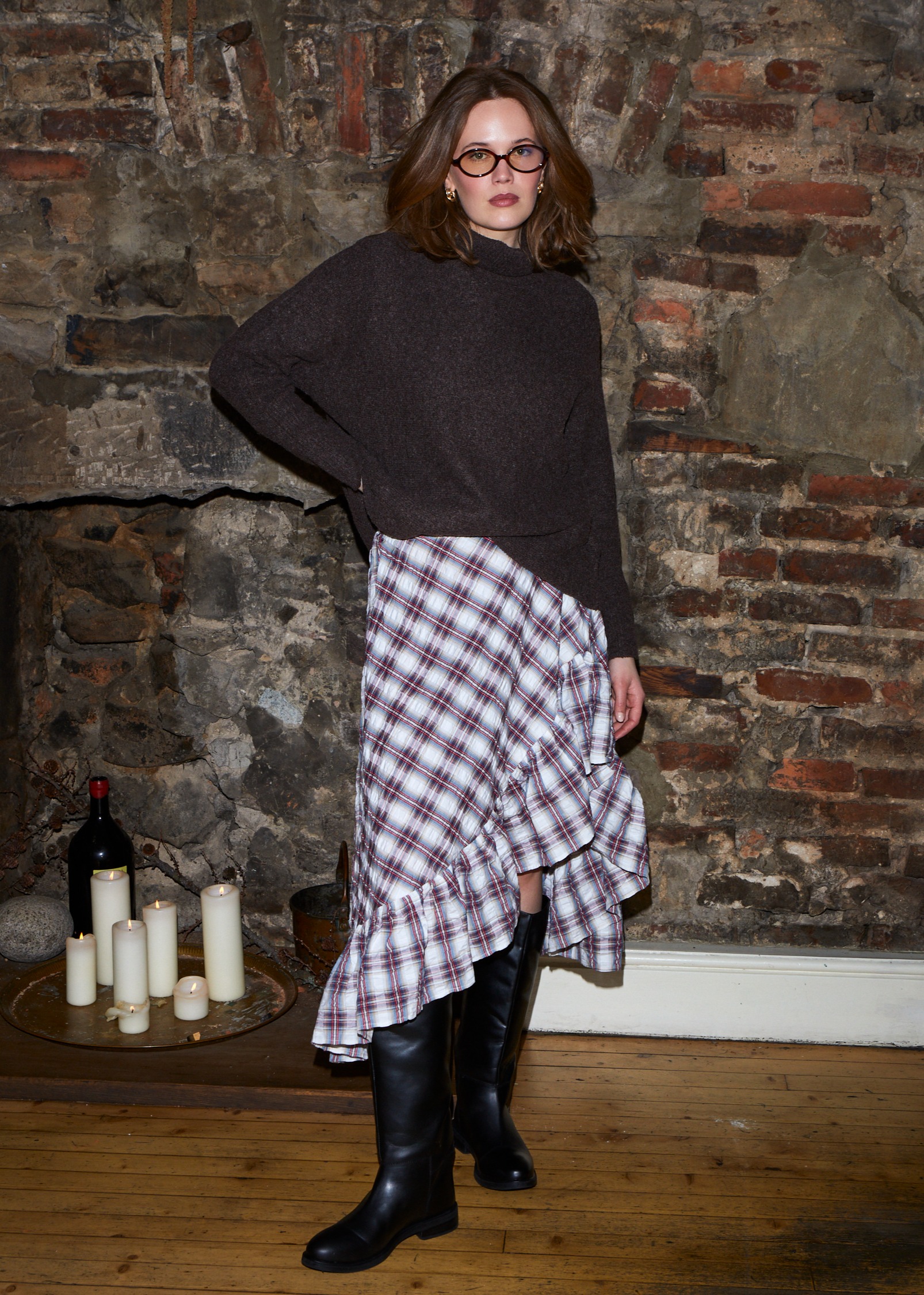 Dunkler Pullover trifft auf karierten Rock. 