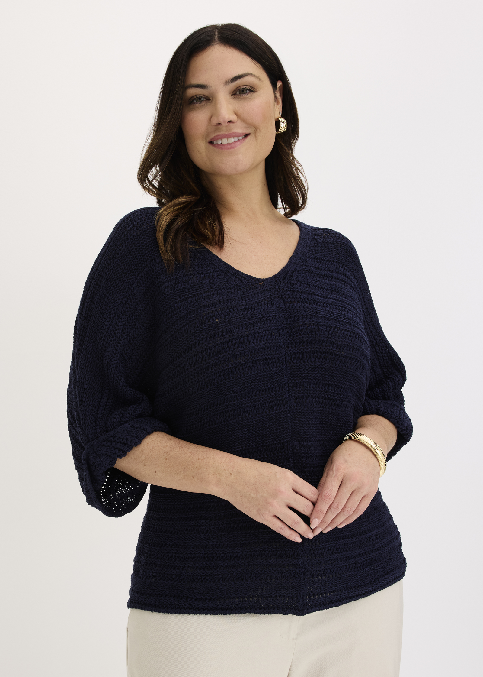 Dunkelblauer Strickpullover mit V-Ausschnitt und 3/4-Ärmeln, kombiniert mit heller Hose.
