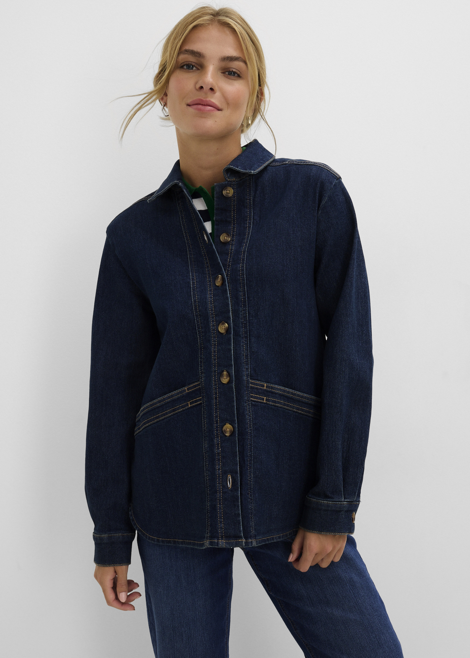 Lässige Jeansjacke mit markanten Nähten, dazu ein gestreiftes Polo-Shirt und Jeans.