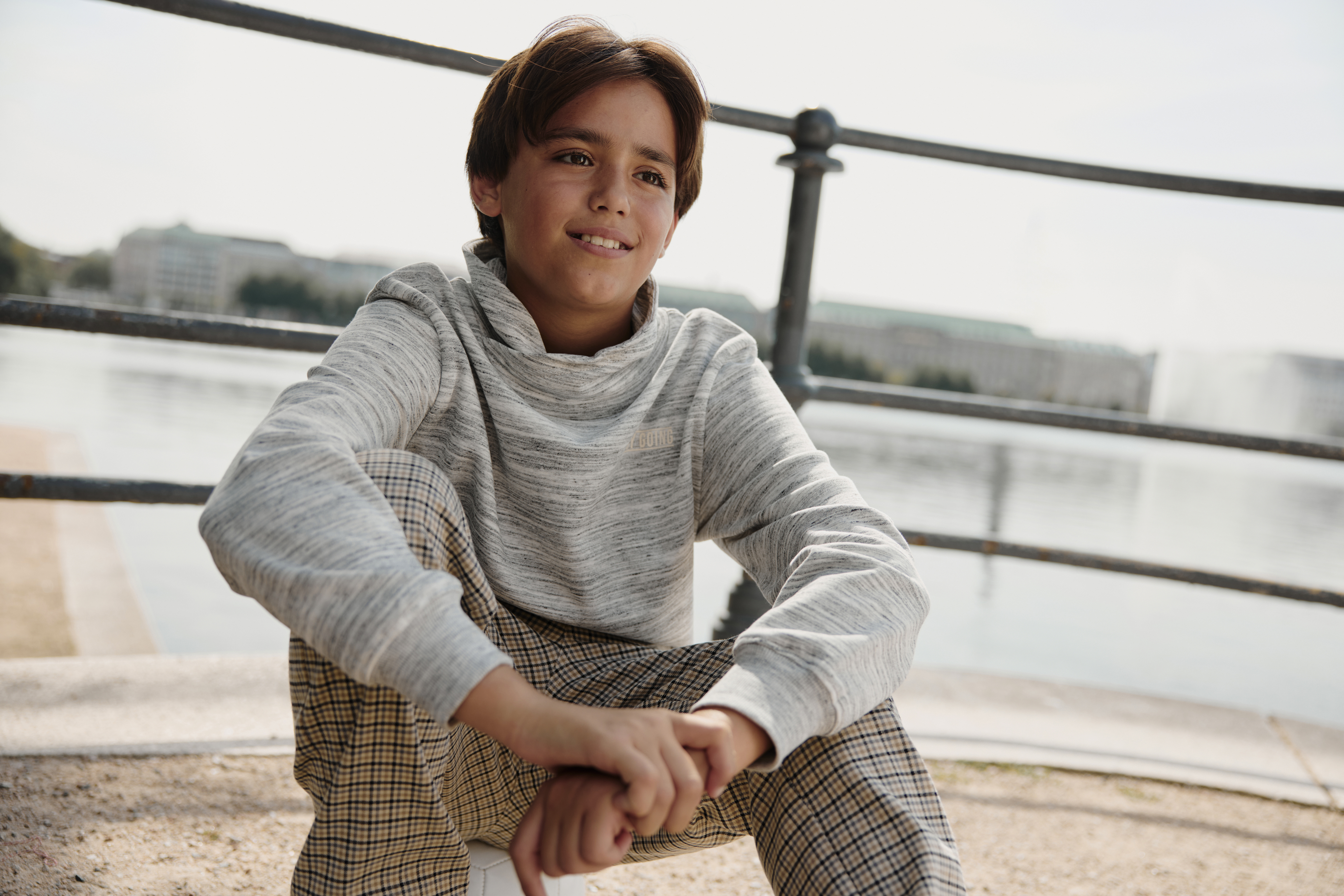 Gemütlicher grauer Pullover und karierte Hose - perfekt für einen entspannten Tag am Wasser.