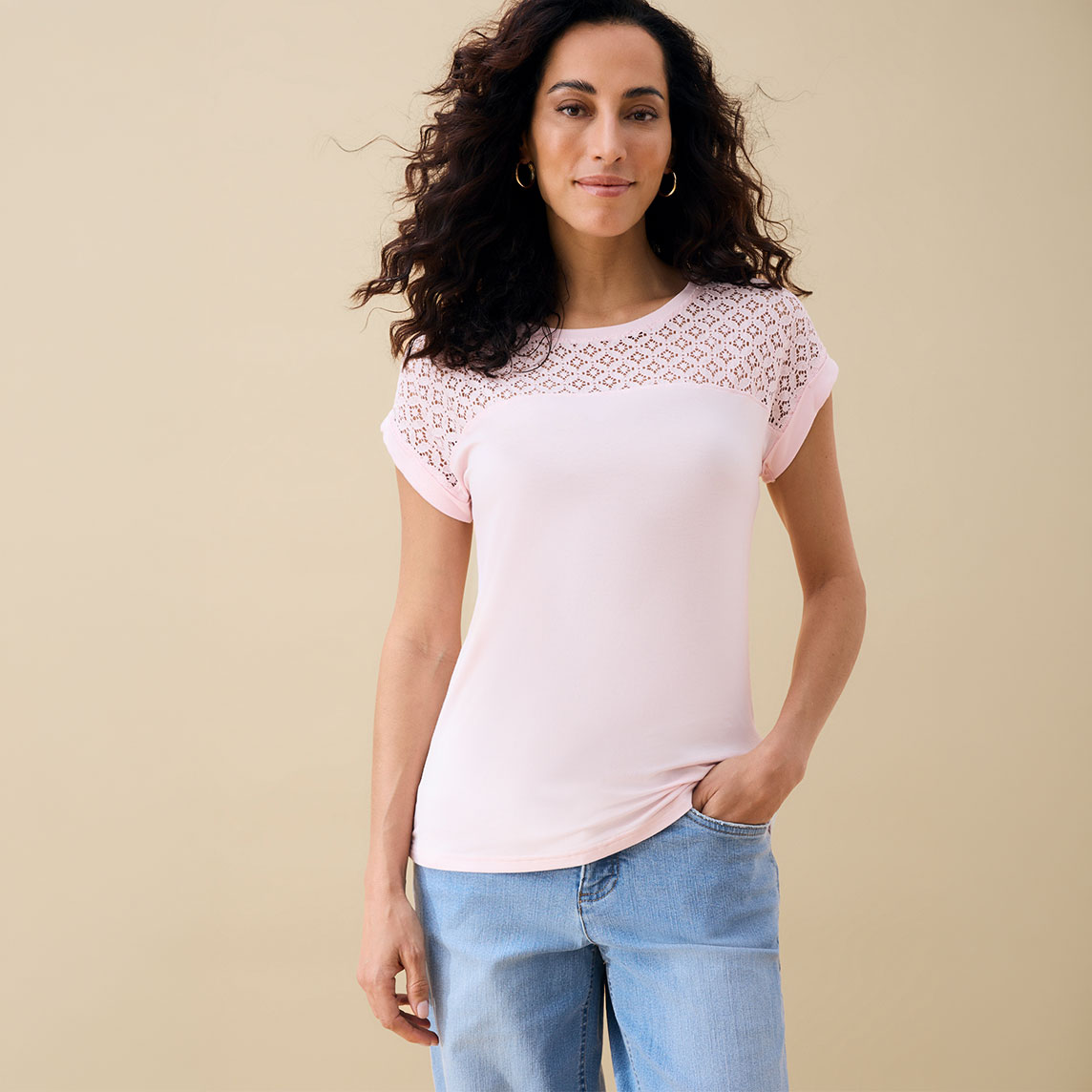 Helles rosa Oberteil mit zarten Lochmustern kombiniert mit lässigen Jeans.