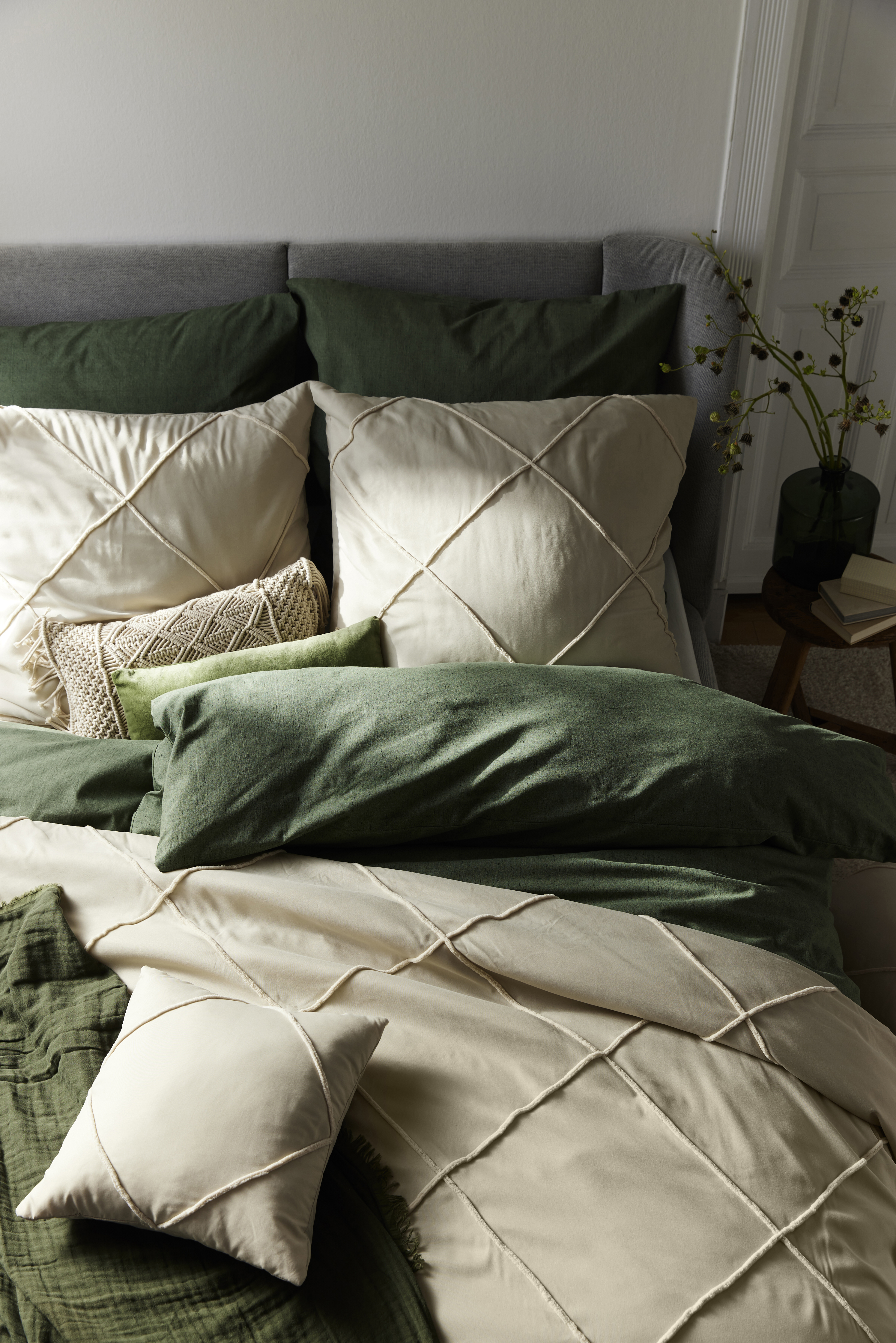 Beige Kissen liegen auf dem Bett.