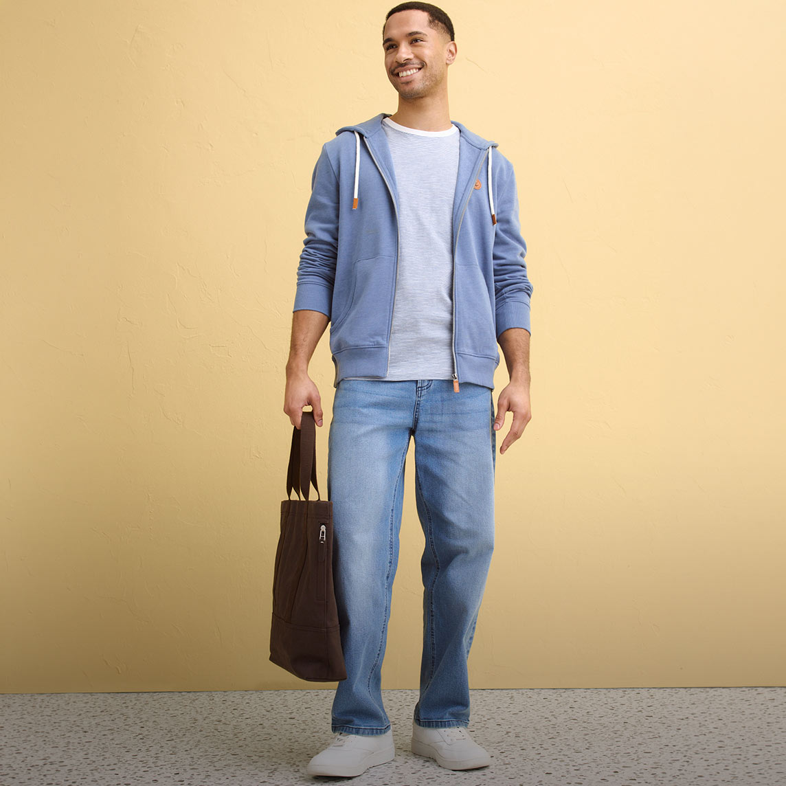 Blauer Hoodie, helles T-Shirt, Jeans und weiße Sneaker kreieren einen entspannten Stil.
