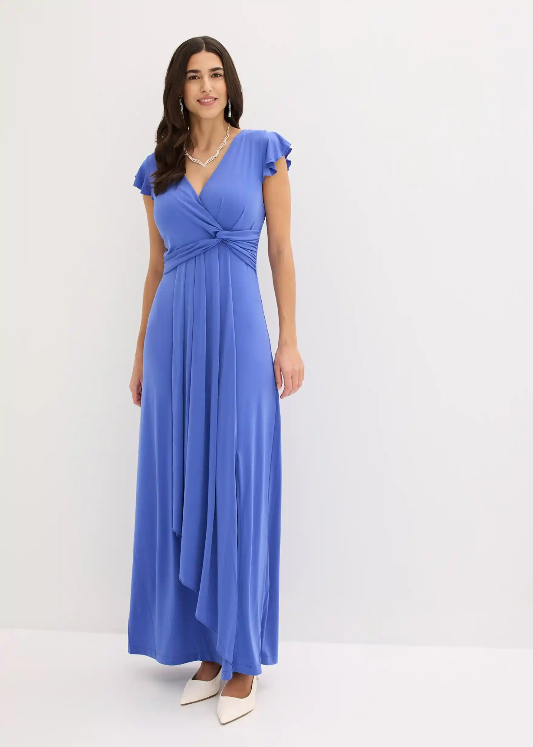 Elegantes blaues Maxikleid mit Wickeldetails, fließendem Rock und weißen Pumps.