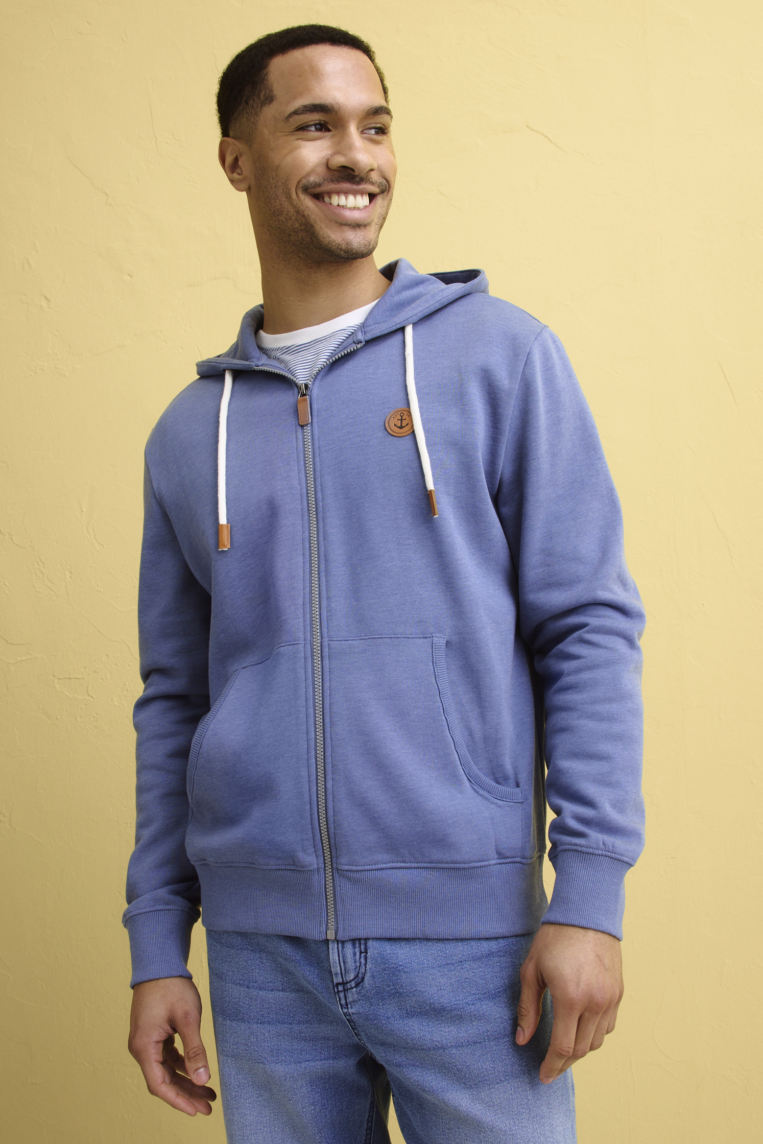 Hellblaue Kapuzenjacke mit Reißverschluss und Känguru-Tasche, kombiniert mit einer klassischen Jeans.