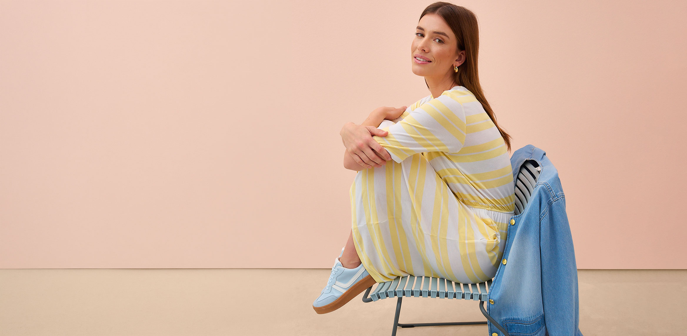 Frau trägt gelb-weiß gestreiftes Kleid.